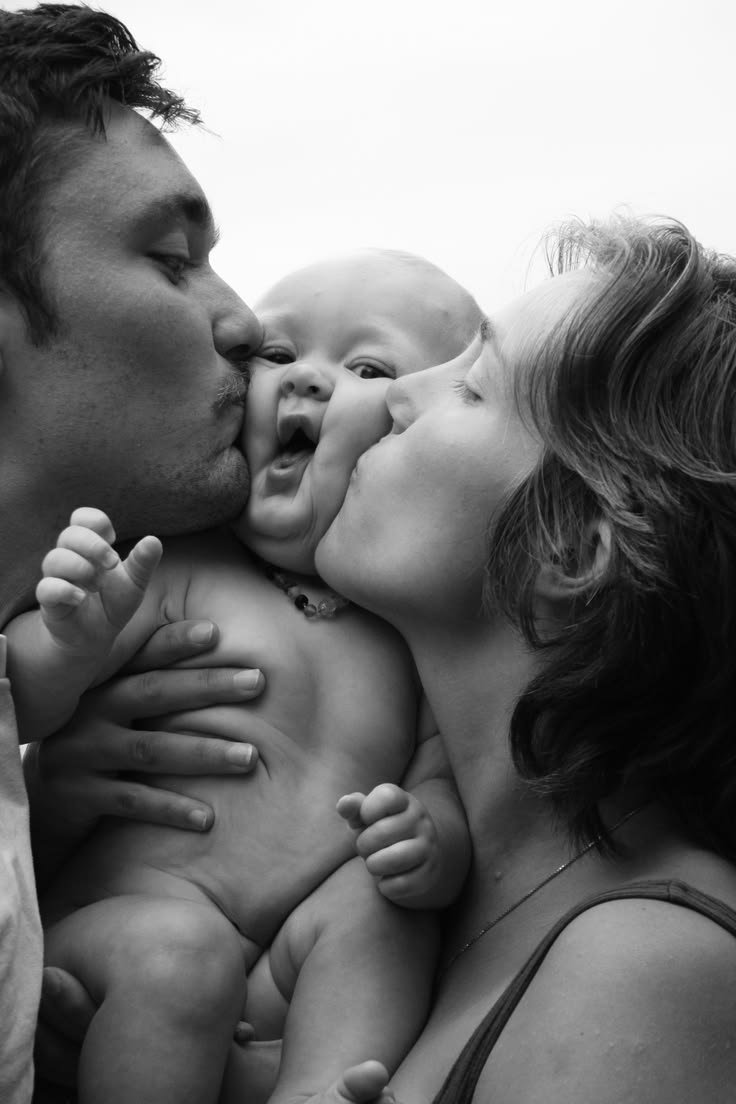 A mom and dad kissing their babies cheek smushing its face