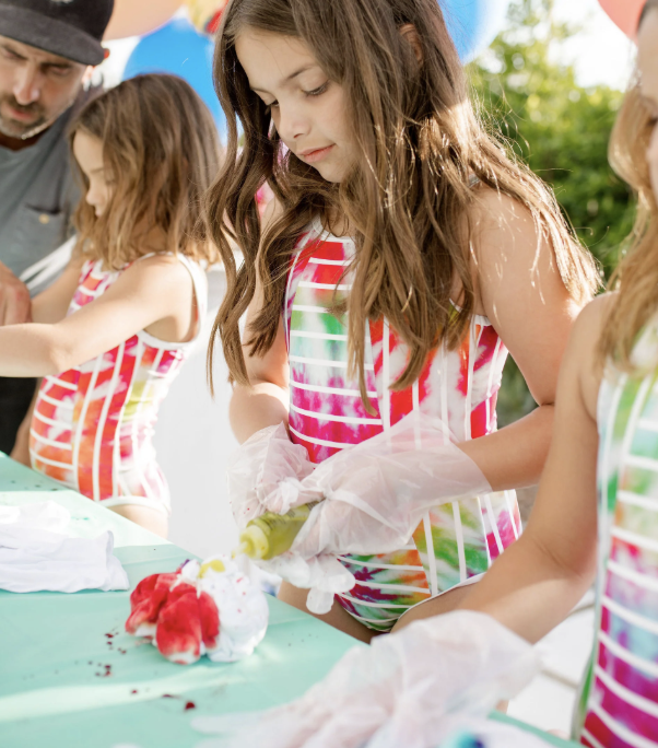 Children in colorful swimsuits making ice cream sundaes outdoors on a sunny day. kids soiree craft activity parties
