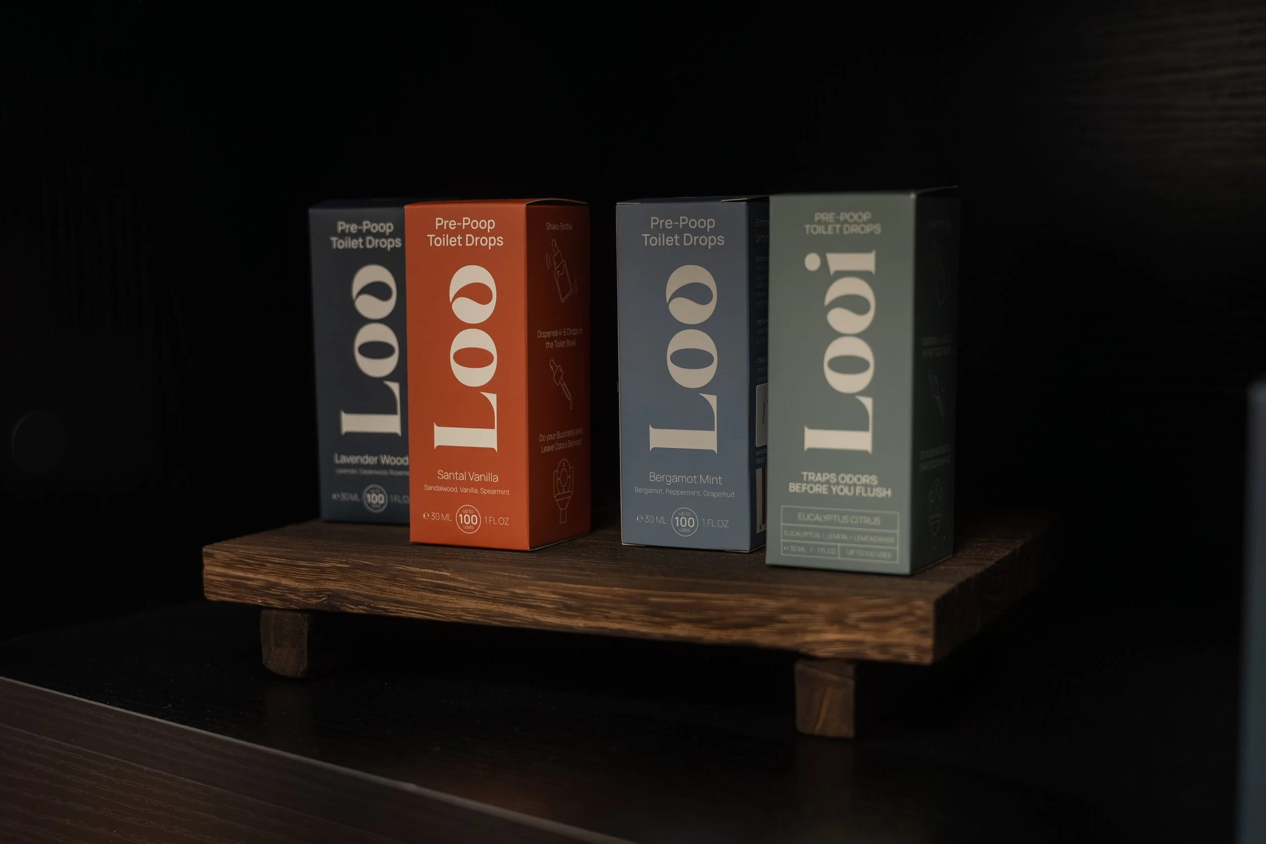Boxes of pre-poop toilet drops in lavender wood, santal vanilla, bergamot mint, and eucalyptus citrus flavors on a wooden shelf available to purchase in Lacombe Alberta.