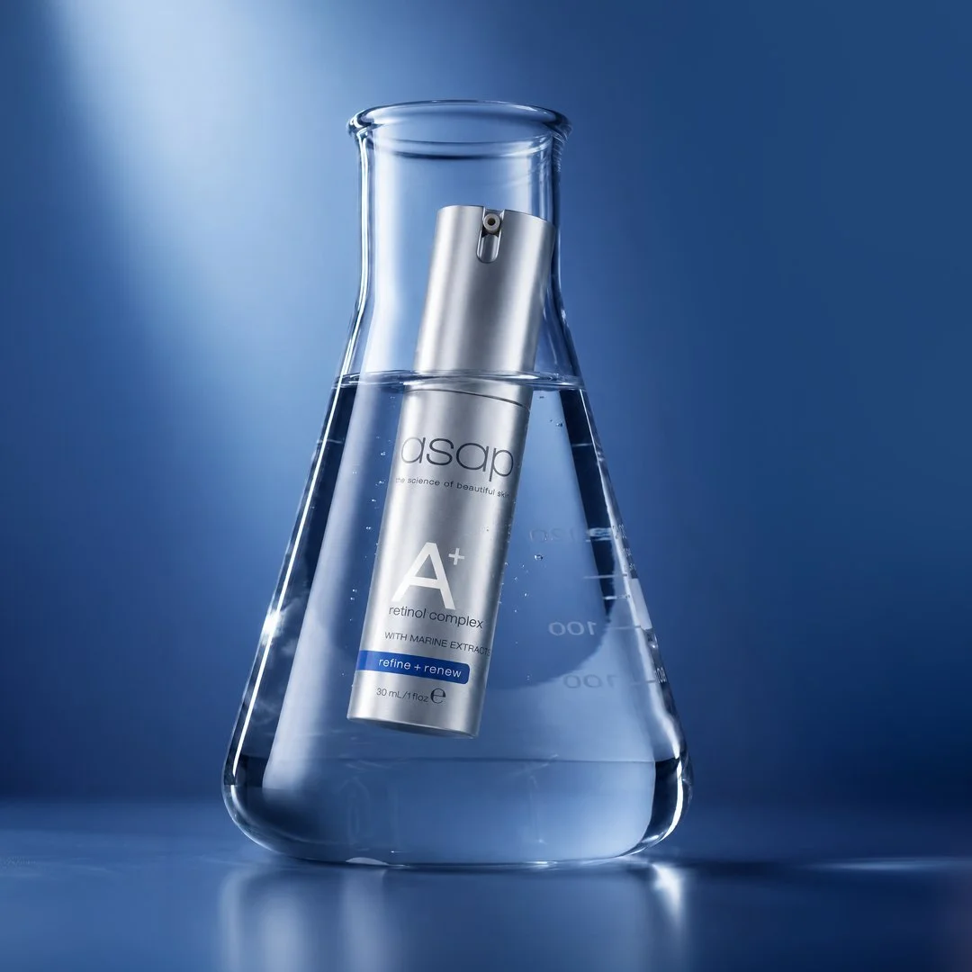 A clear glass beaker filled with water, containing a silver bottle labeled 'asap' with