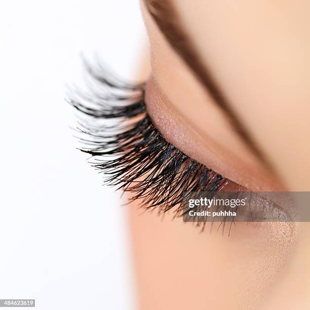 Close-up of a person's closed eye with long, thick eyelashes.