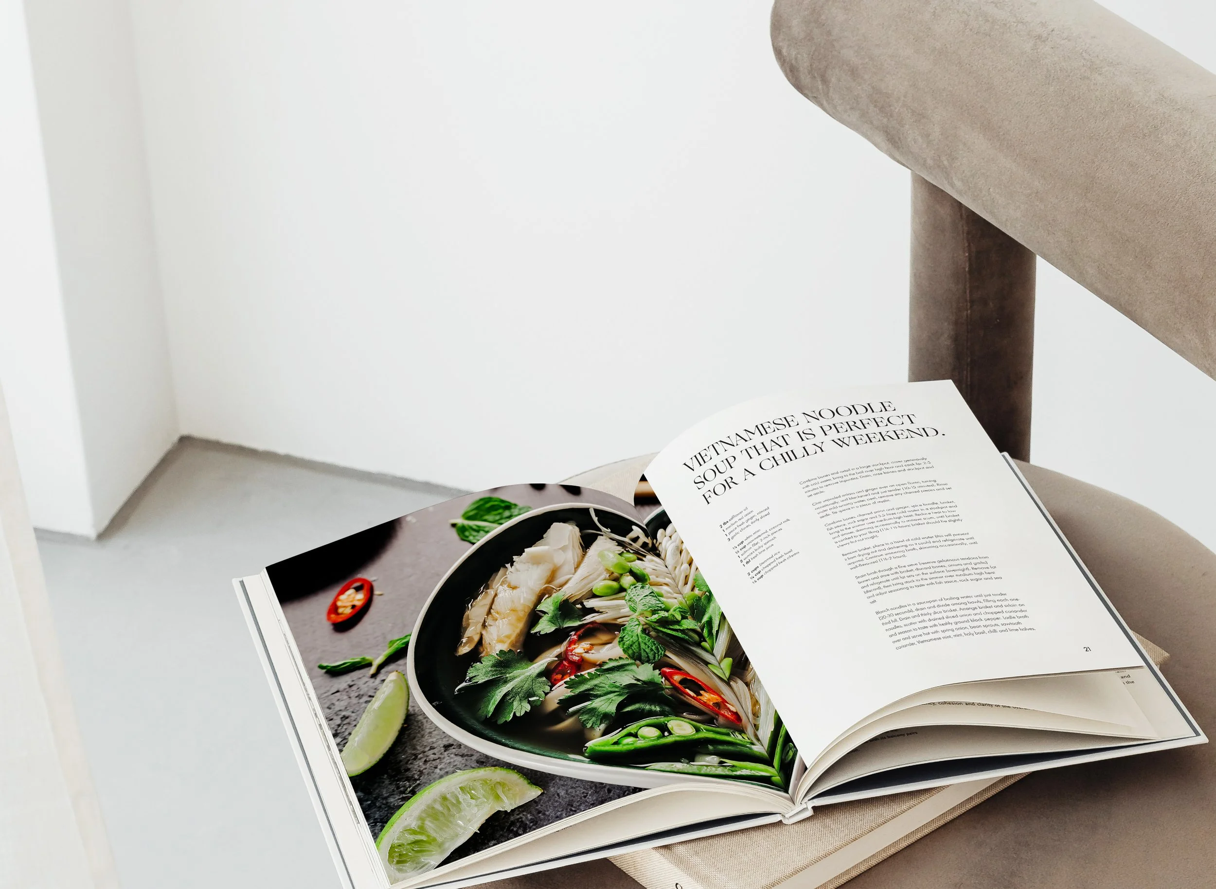 Open cookbook displaying a Vietnamese noodle soup recipe with an image of a bowl of noodle soup garnished with herbs and chili peppers.
