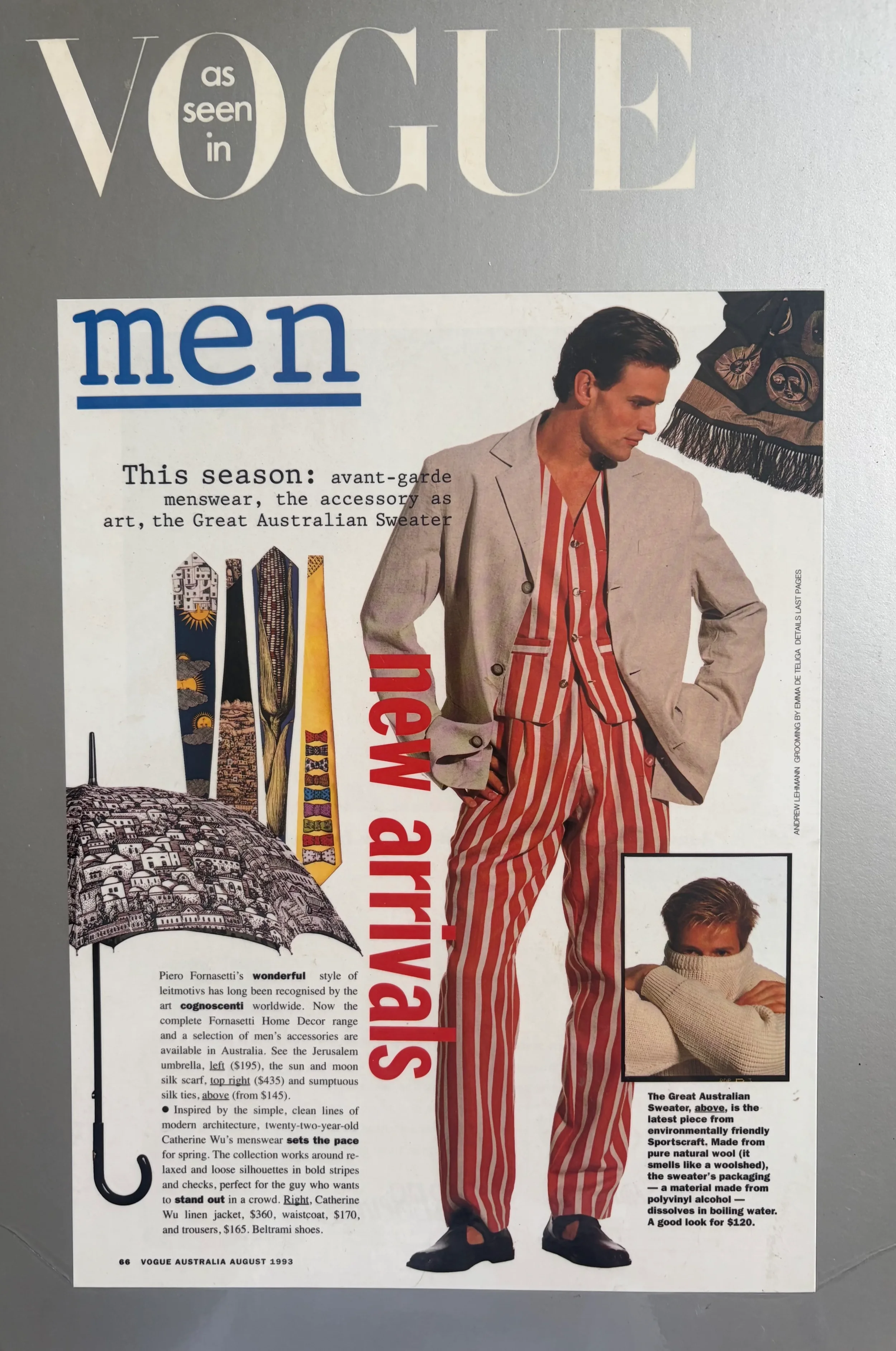 Page from Vogue Australia August 1993 featuring a man in a beige blazer and red striped pants standing next to a woman in an oversized beige sweater, with a small inset photo of the woman’s face. The page includes text about Australian fashion and accessories, with the title "Vogue as seen in men." There are also illustrations of an umbrella and umbrellas with Australian motifs.