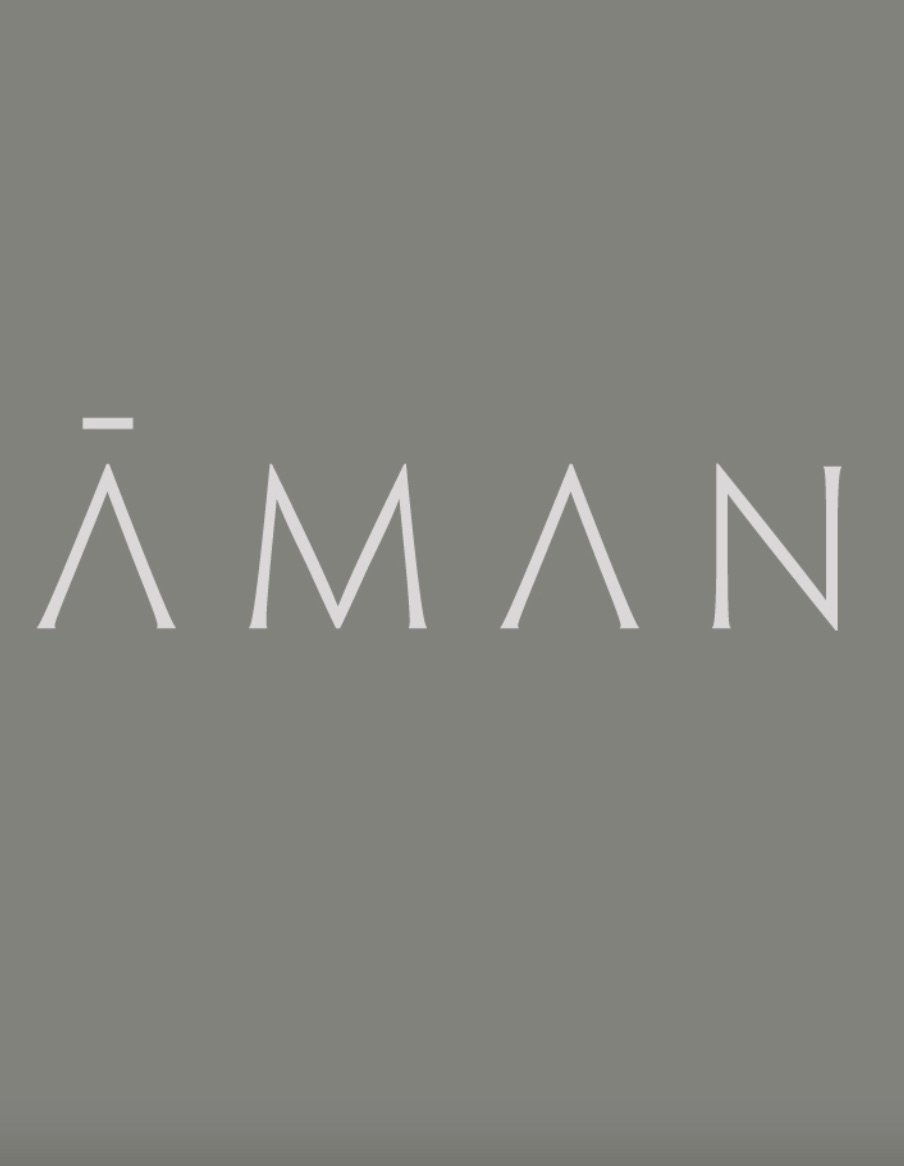 The offical logo of Aman Resorts and Hotels consisting of stylized letters on a gray background.