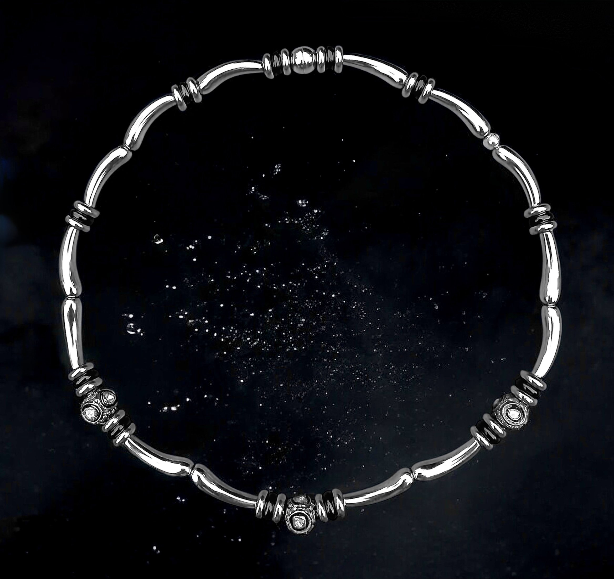 Silver bead bracelet with black accents against a black background