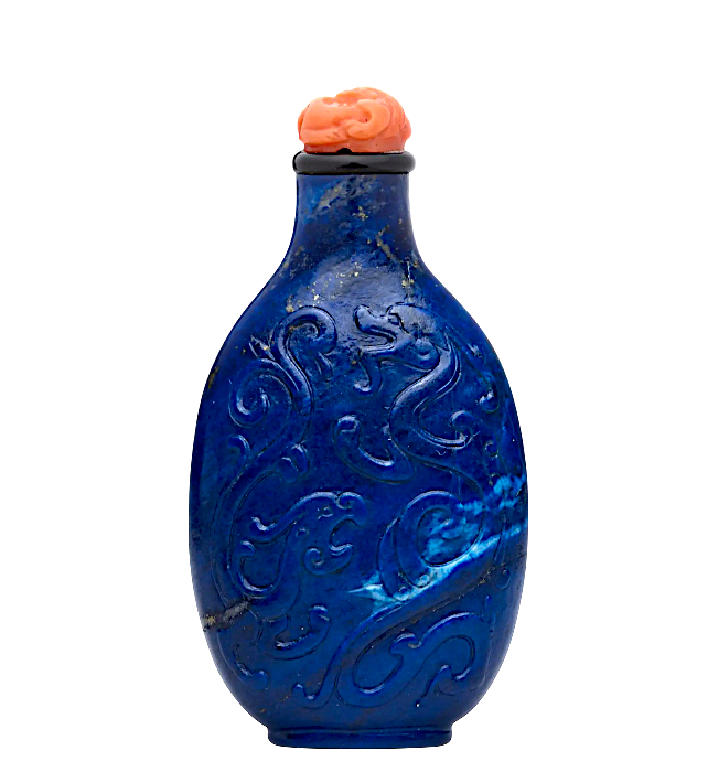 Blue decorative bottle with intricate carvings and a coral-like stopper.