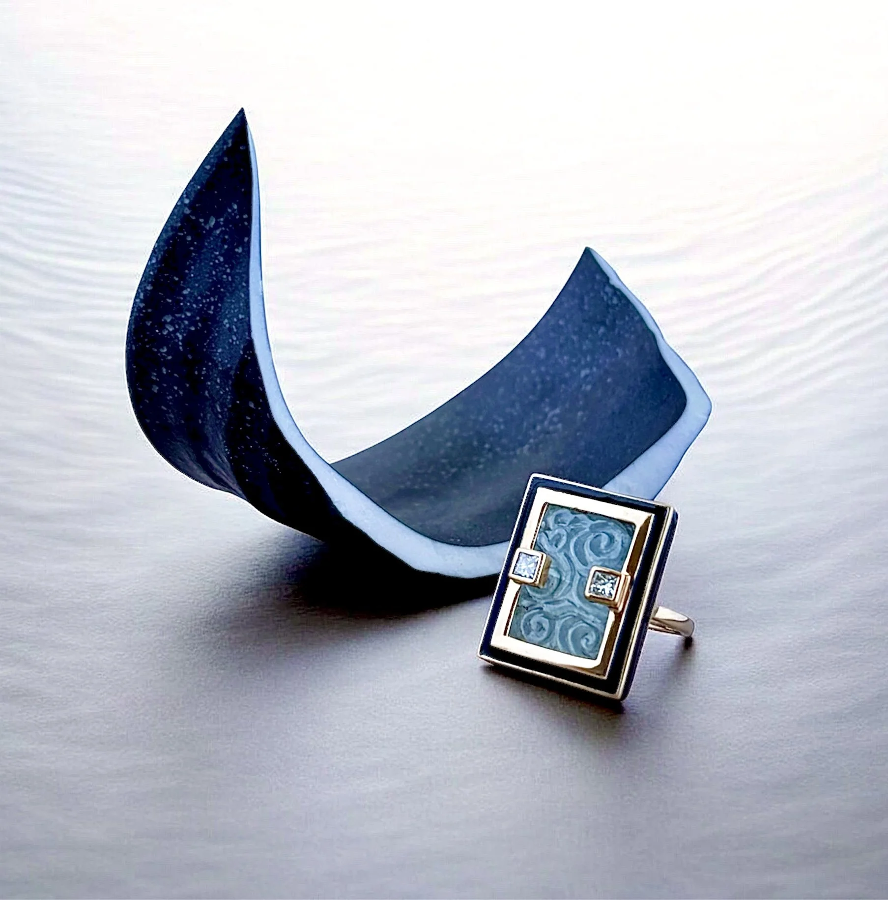 hand carved aquamarine cloud design ring with black enamel and diamond frame.