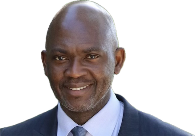 A smiling man in a suit and tie, looking directly at the camera.