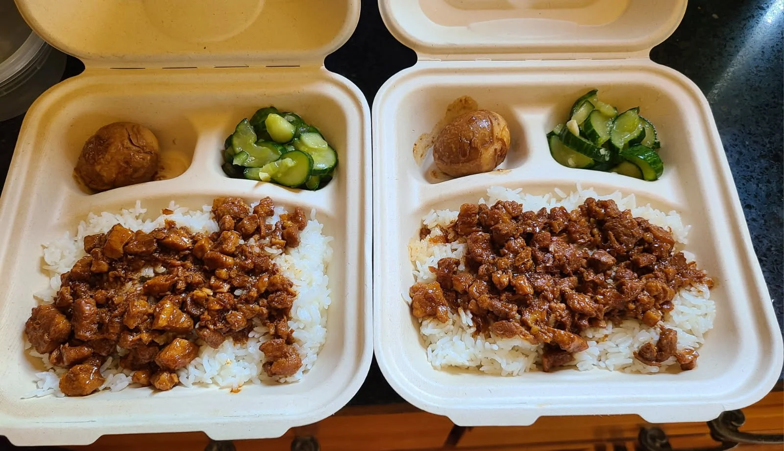 Two Sons Taiwanese bian dang with Taiwanese braised pork, braised egg, and smashed cucumbers - in meal boxes.