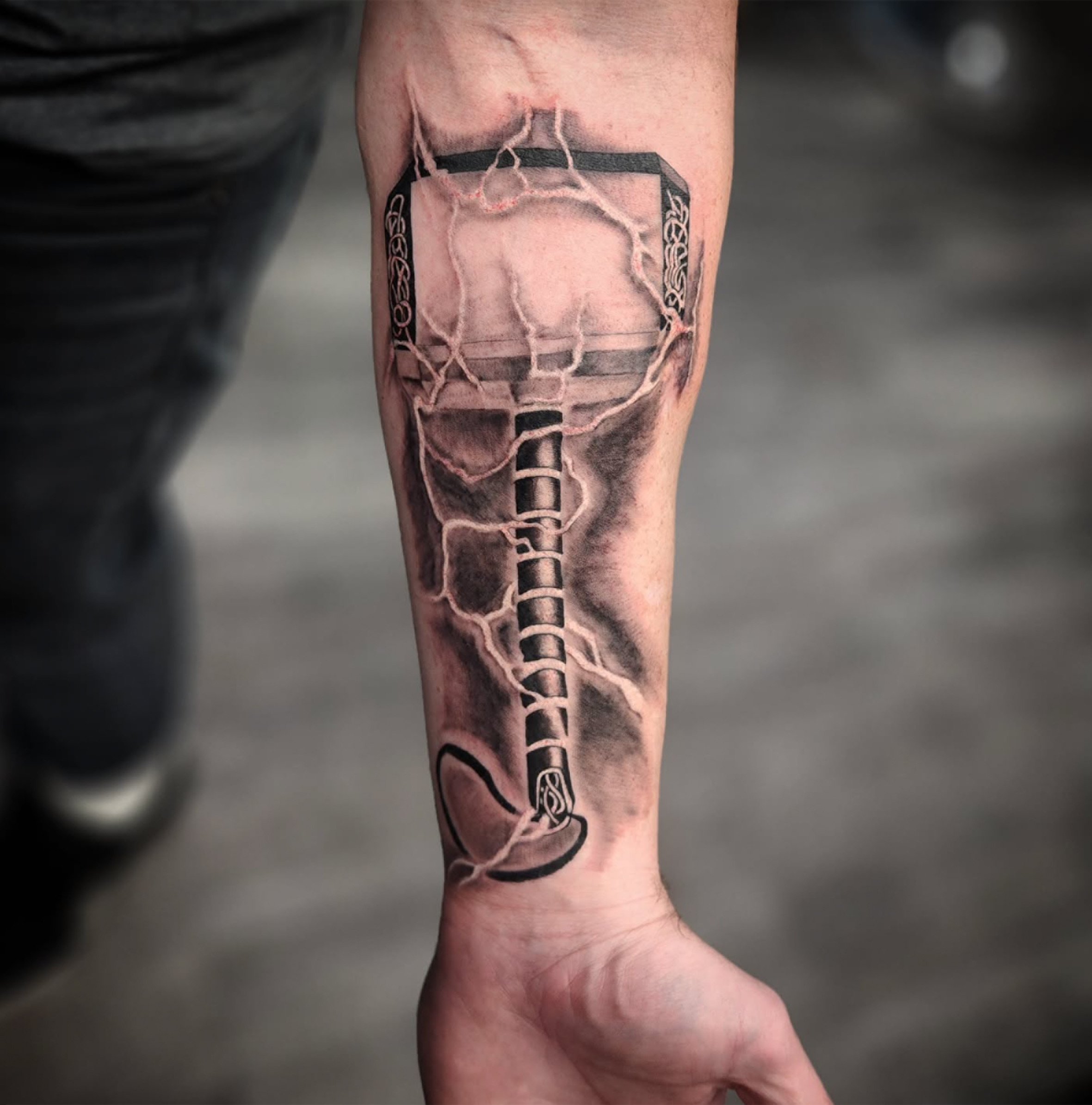 Tattoo of a basketball hoop, net, and ball on a person's forearm.