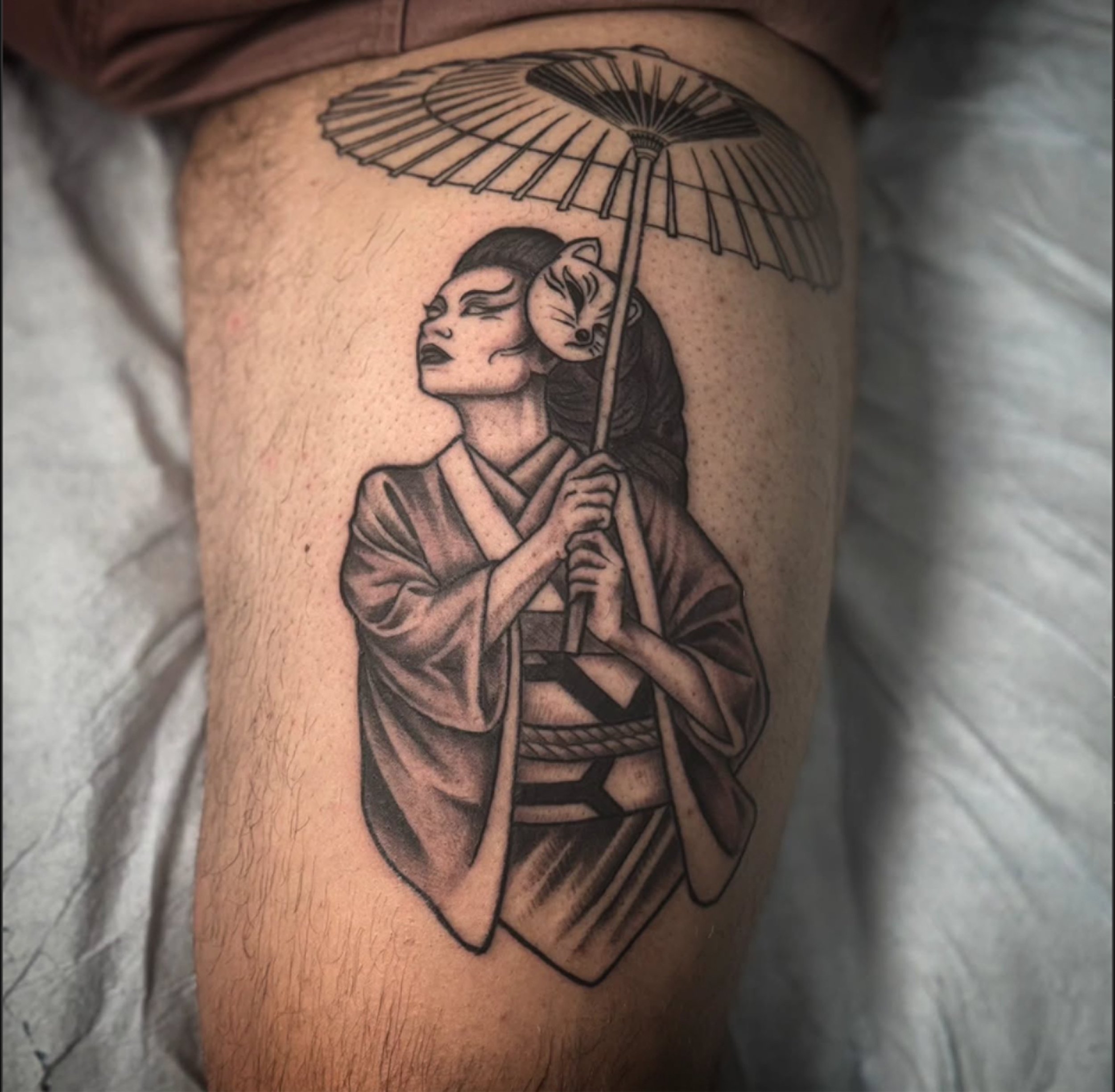 Tattoo of a woman holding an umbrella with a wolf face on her head.