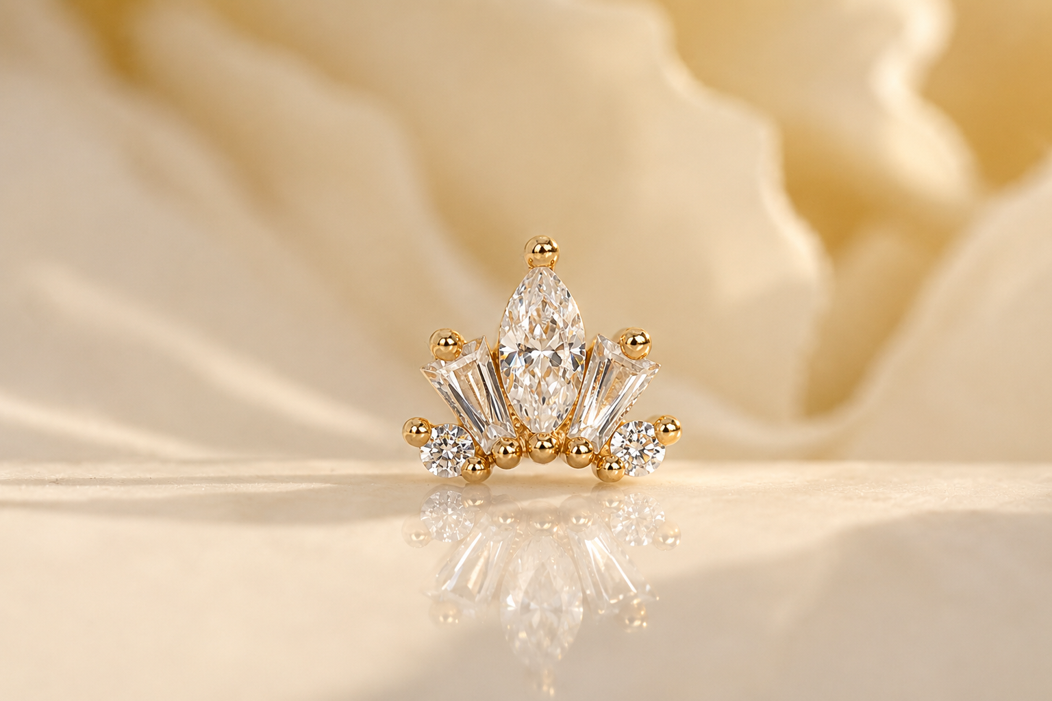 A gold and diamond decorative piece with a large marquise-cut diamond in the center, flanked by smaller baguette and round-cut diamonds, placed on a reflective surface with a soft gold textured background.
