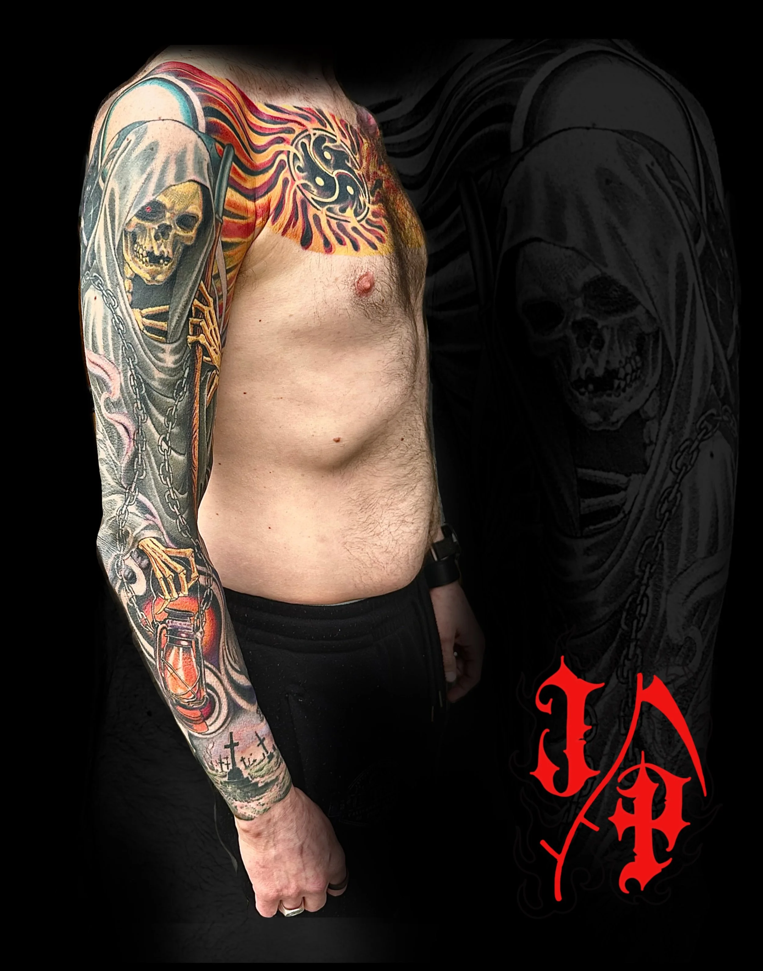 Close-up of left arm with colorful tattoos of a skull, fire, chains, and a lighthouse. Part of a black shirt with red gothic-style lettering is visible on the right side.