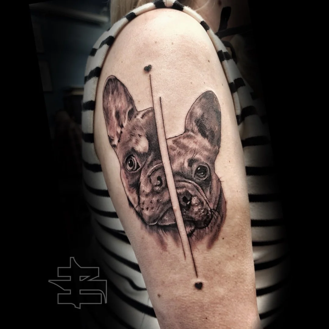 Tattoo of a French Bulldog's face, split by a vertical line with small heart shapes at the top and bottom of the line.