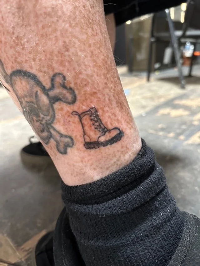 Tattoo of a roller skate on a person's ankle.