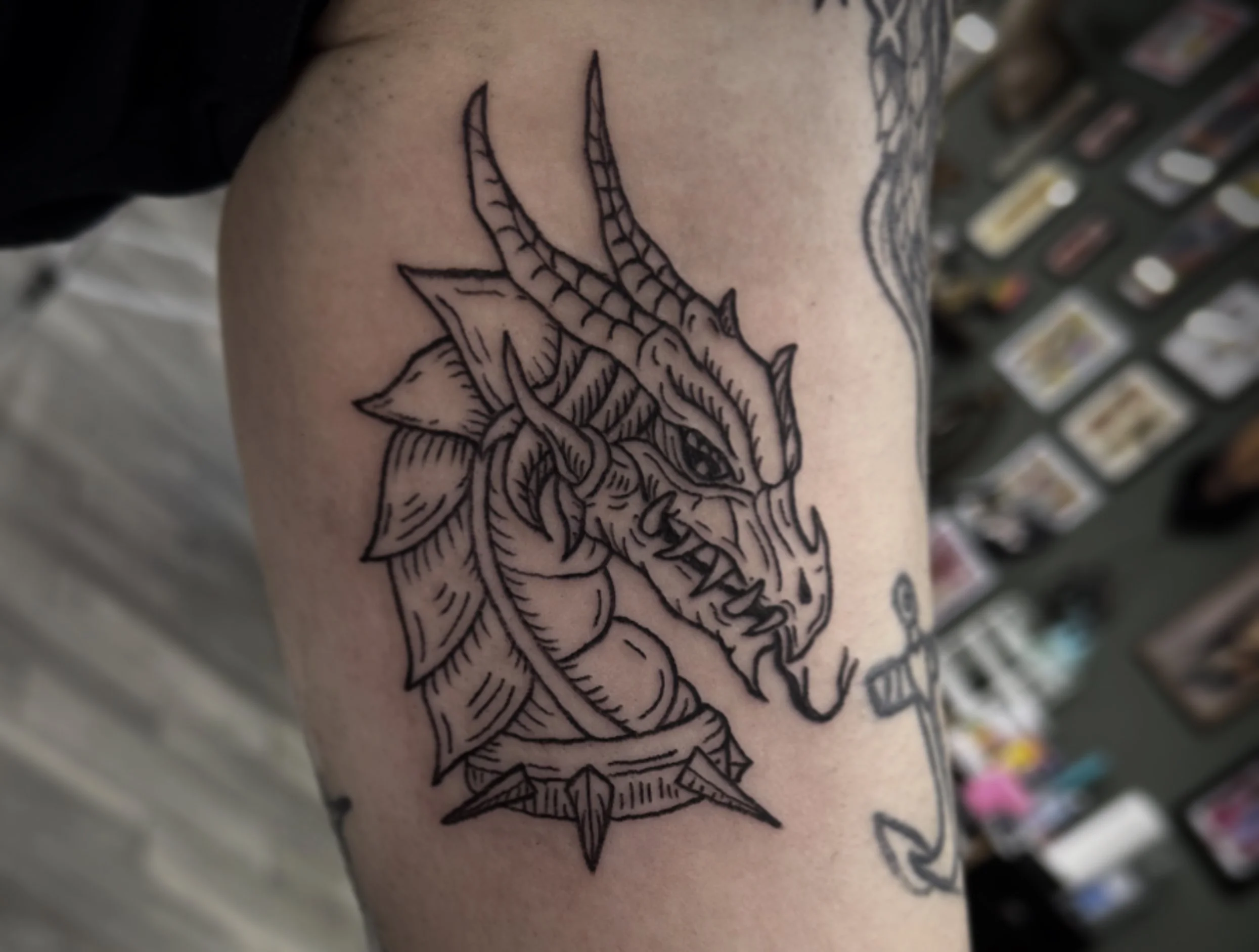Tattoo of a deer skull with antlers on person's arm, outlined in black ink.