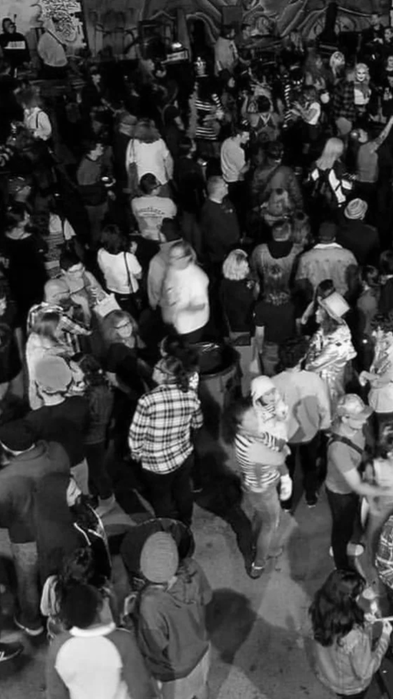 Crowded indoor space with many people, some standing in line, some walking, and others talking, possibly at an event or busy venue.