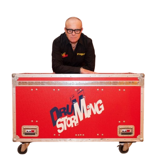 Vittorio Simonelli dietro una grande cassa rossa per strumenti a percussione.