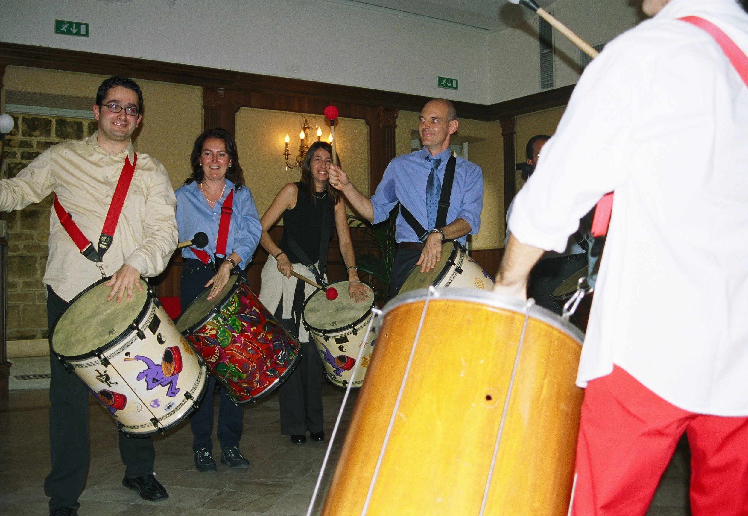 Gruppo di persone che suonano tamburi insieme durante un’esperienza musicale.