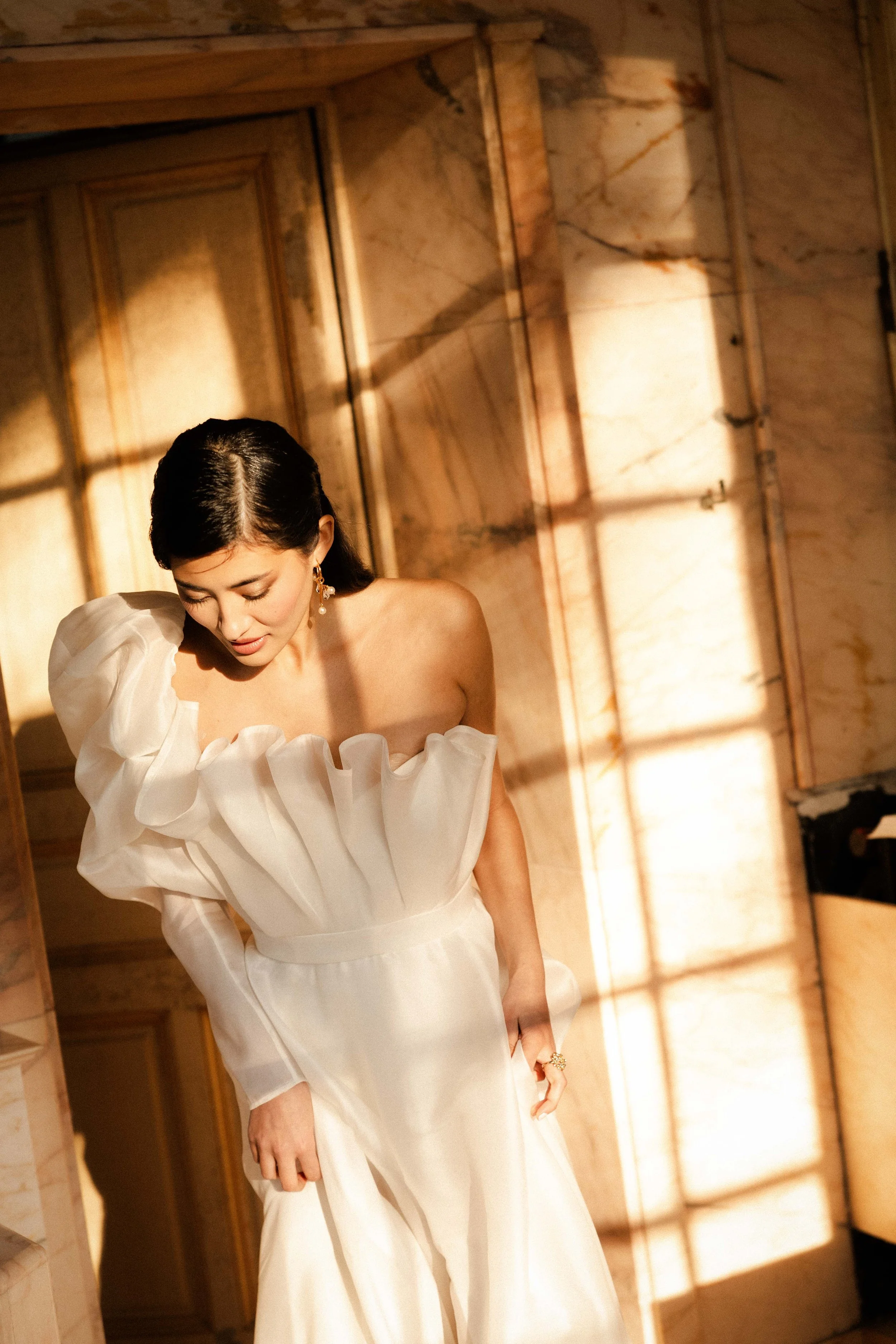 Portrait de profil de la mariée ajustant sa robe dans les coulisses — studio nepita