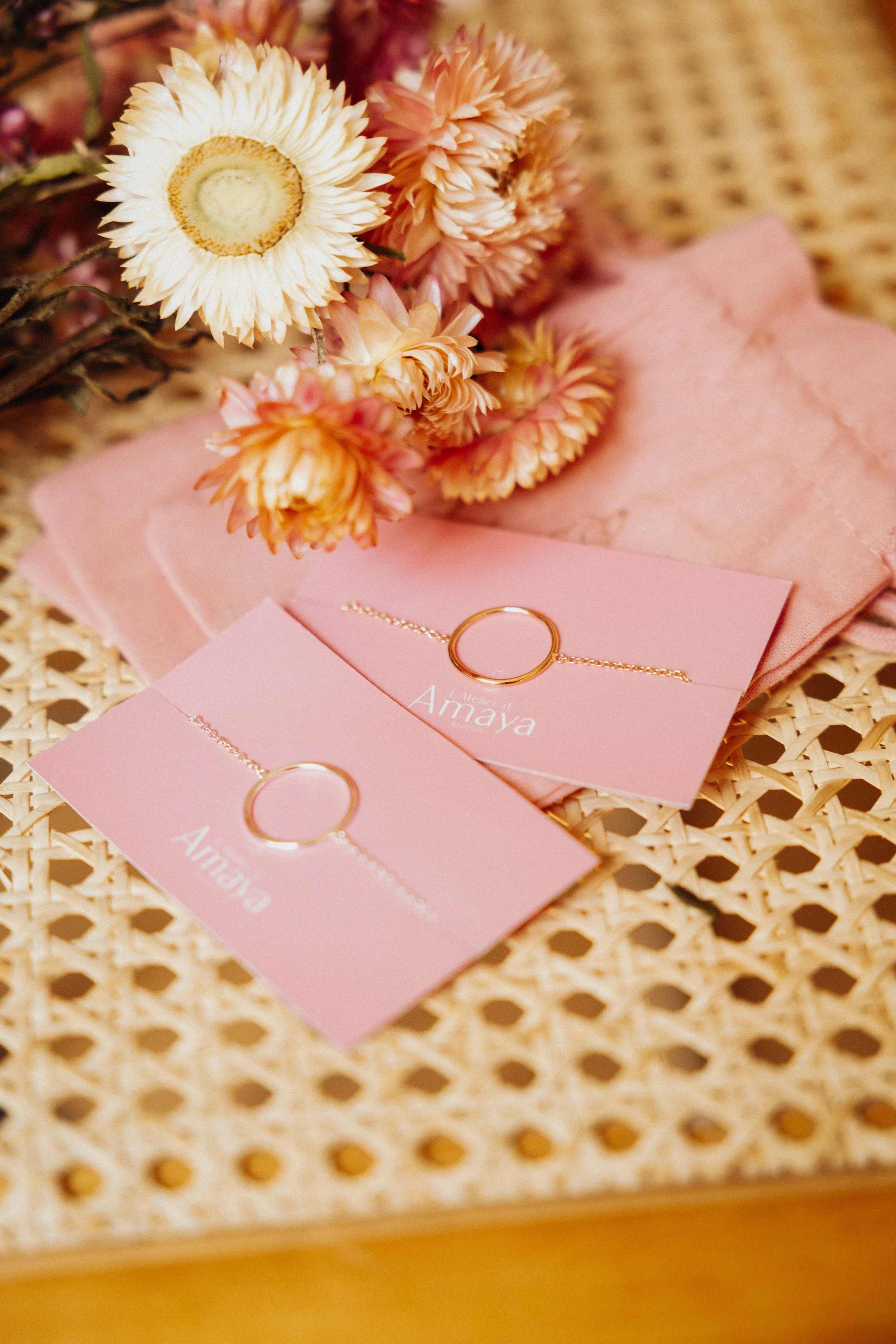 Présentation poétique de bijoux sur éléments de papeterie rose pastel — studio nepita