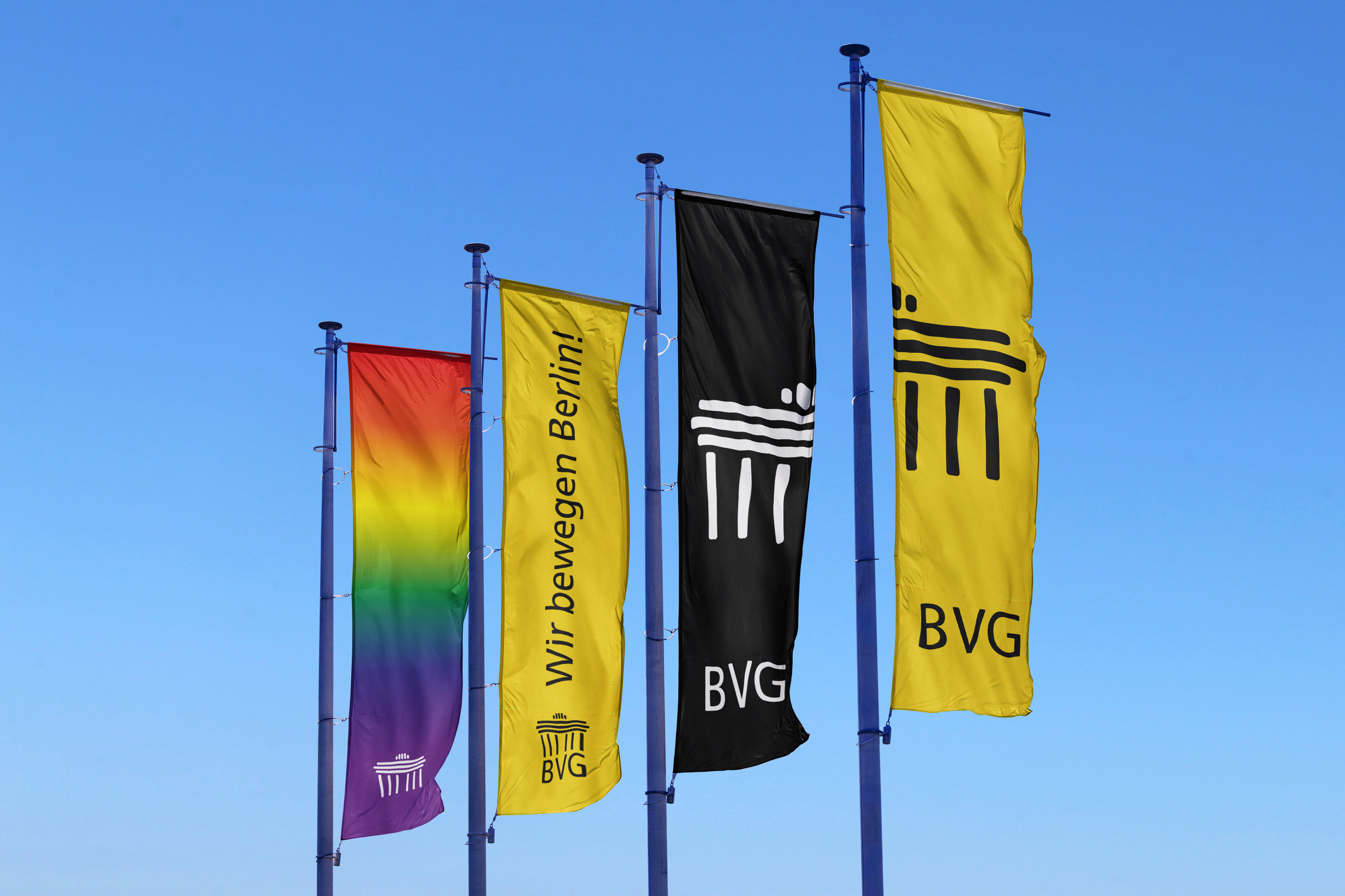 Bunte Flaggen wehen im Wind vor einem blauen Himmel.