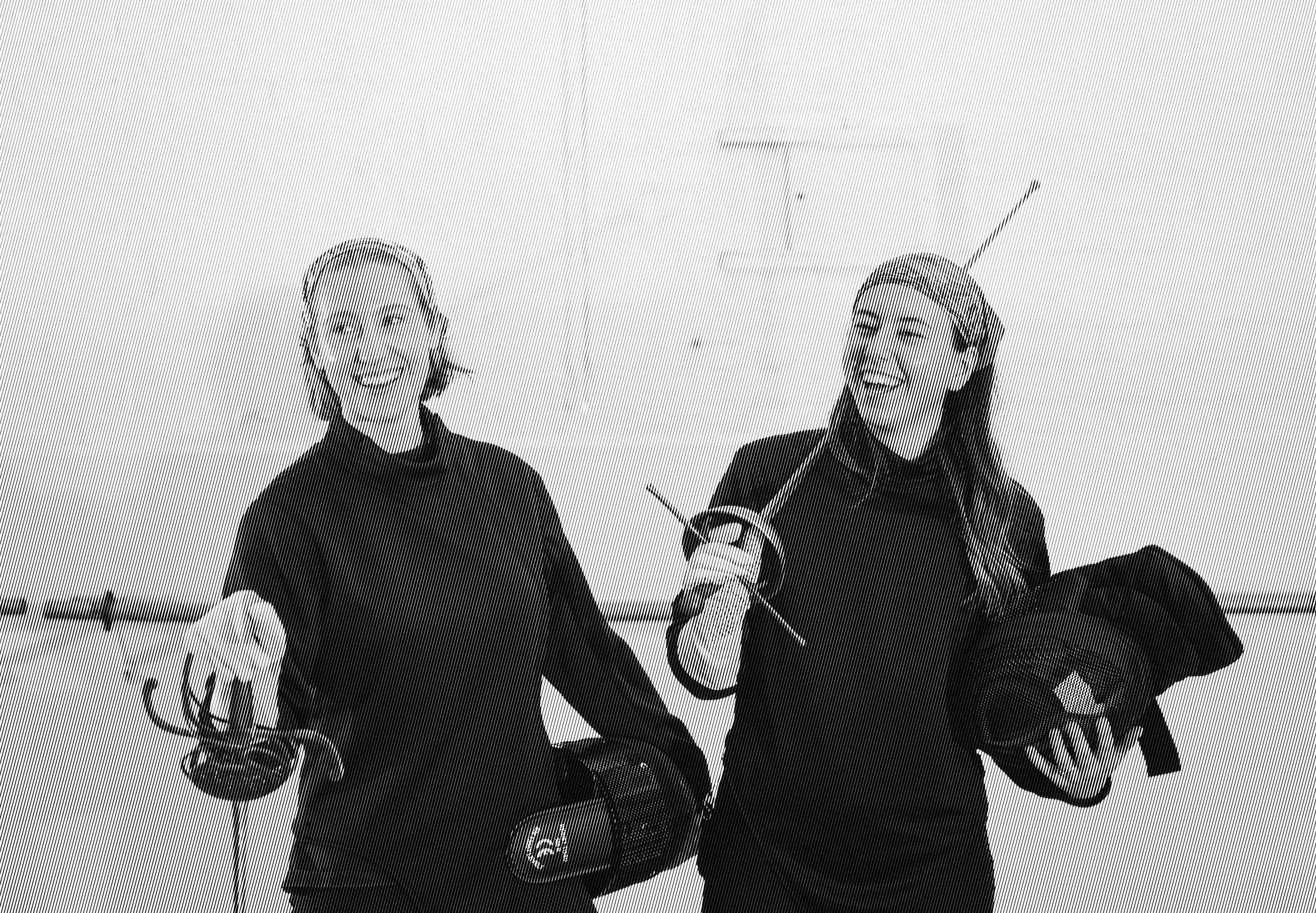 Two young students laughing while holding their swords.