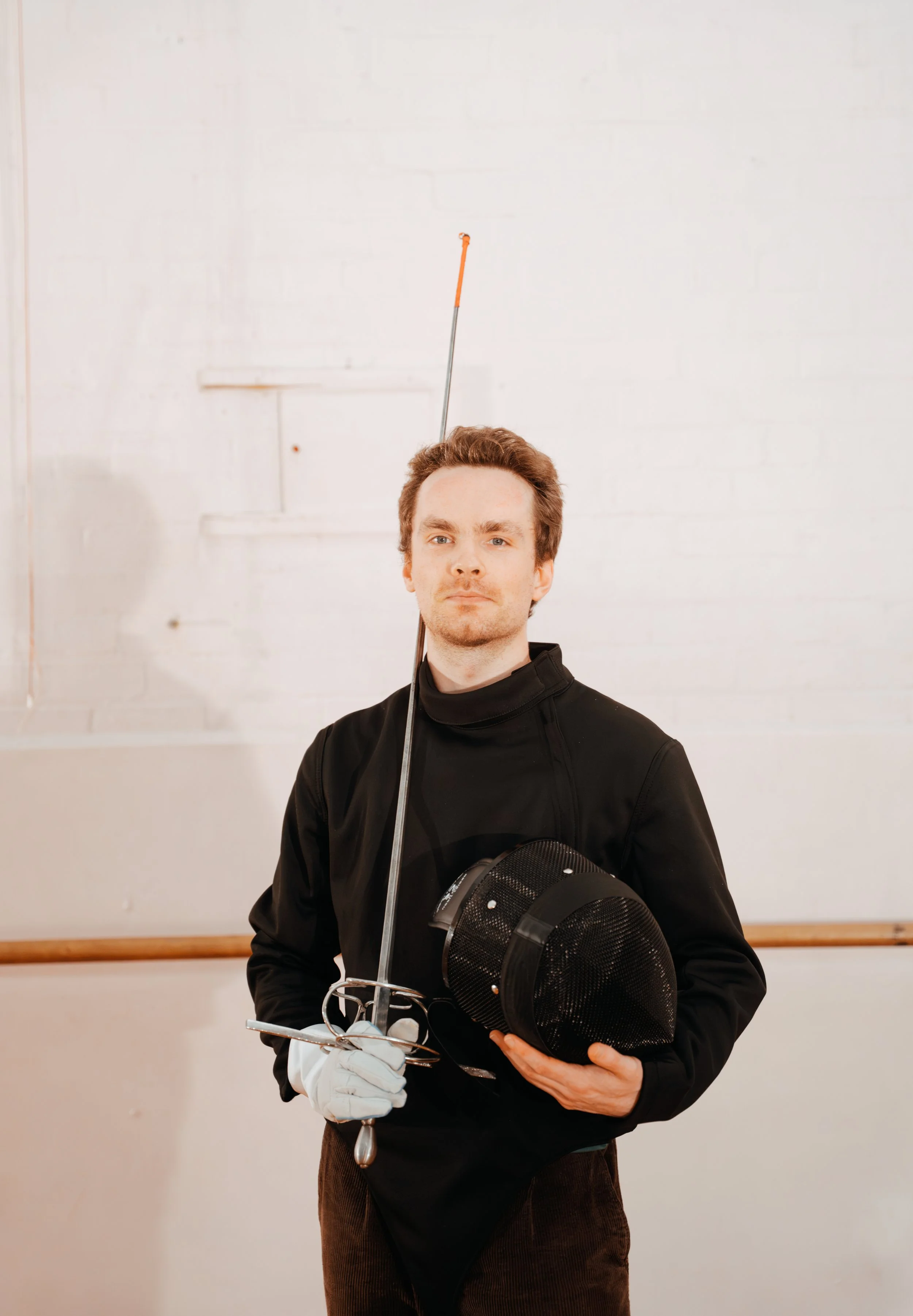 A student of Melbourne Historical Fencing posing, looking proud and confident with his Rapier.