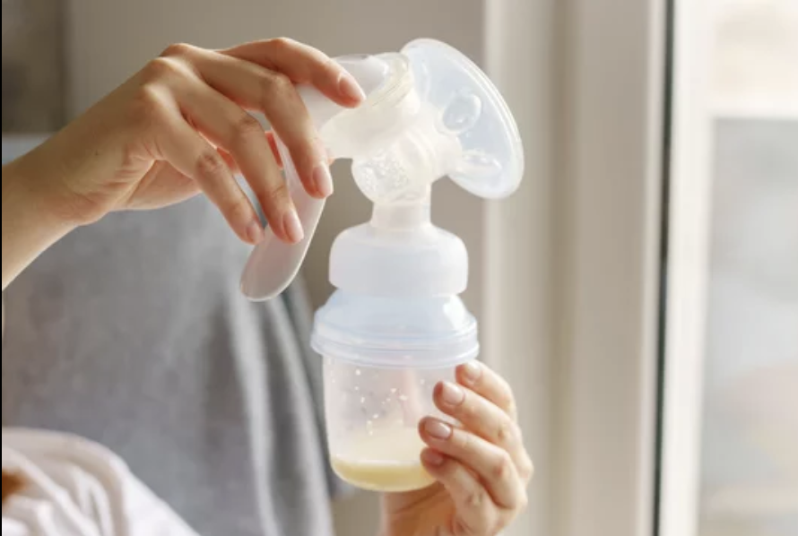 Person using a breast pump to extract milk into a container.