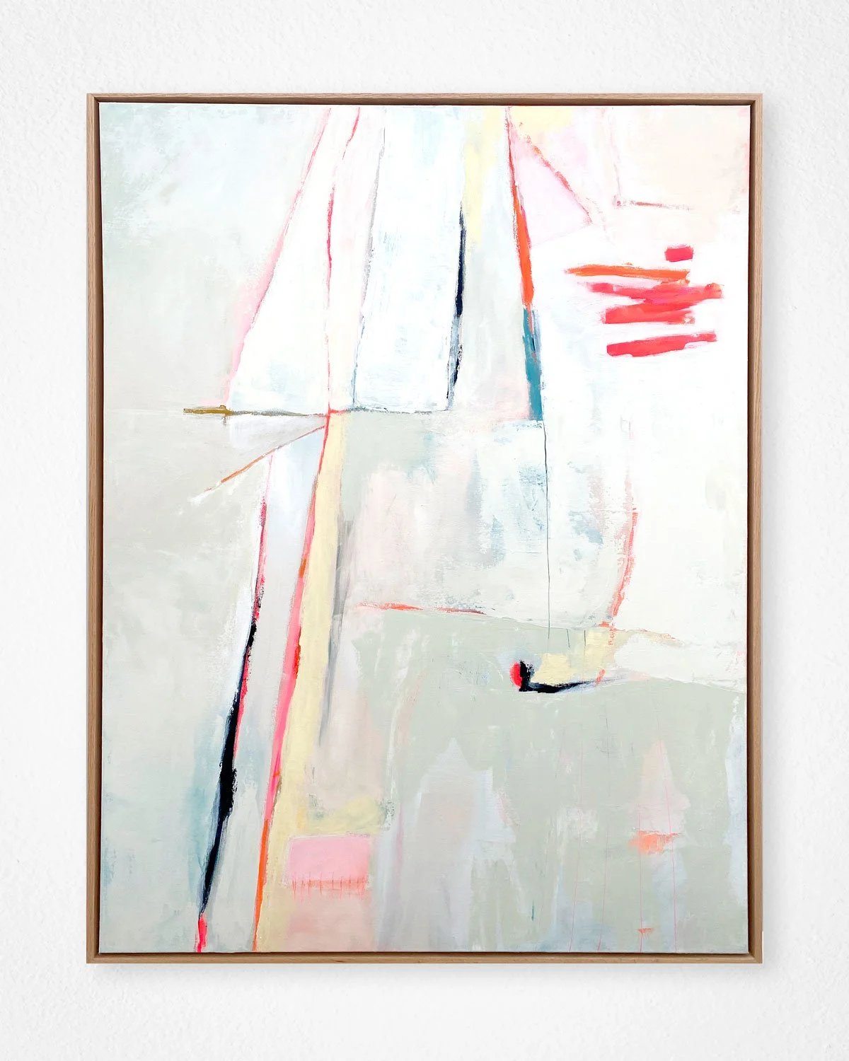 Abstract expressionist painting with soft pastel shades, bold red, black, and blue accents, framed in wood, hanging on a white wall.
