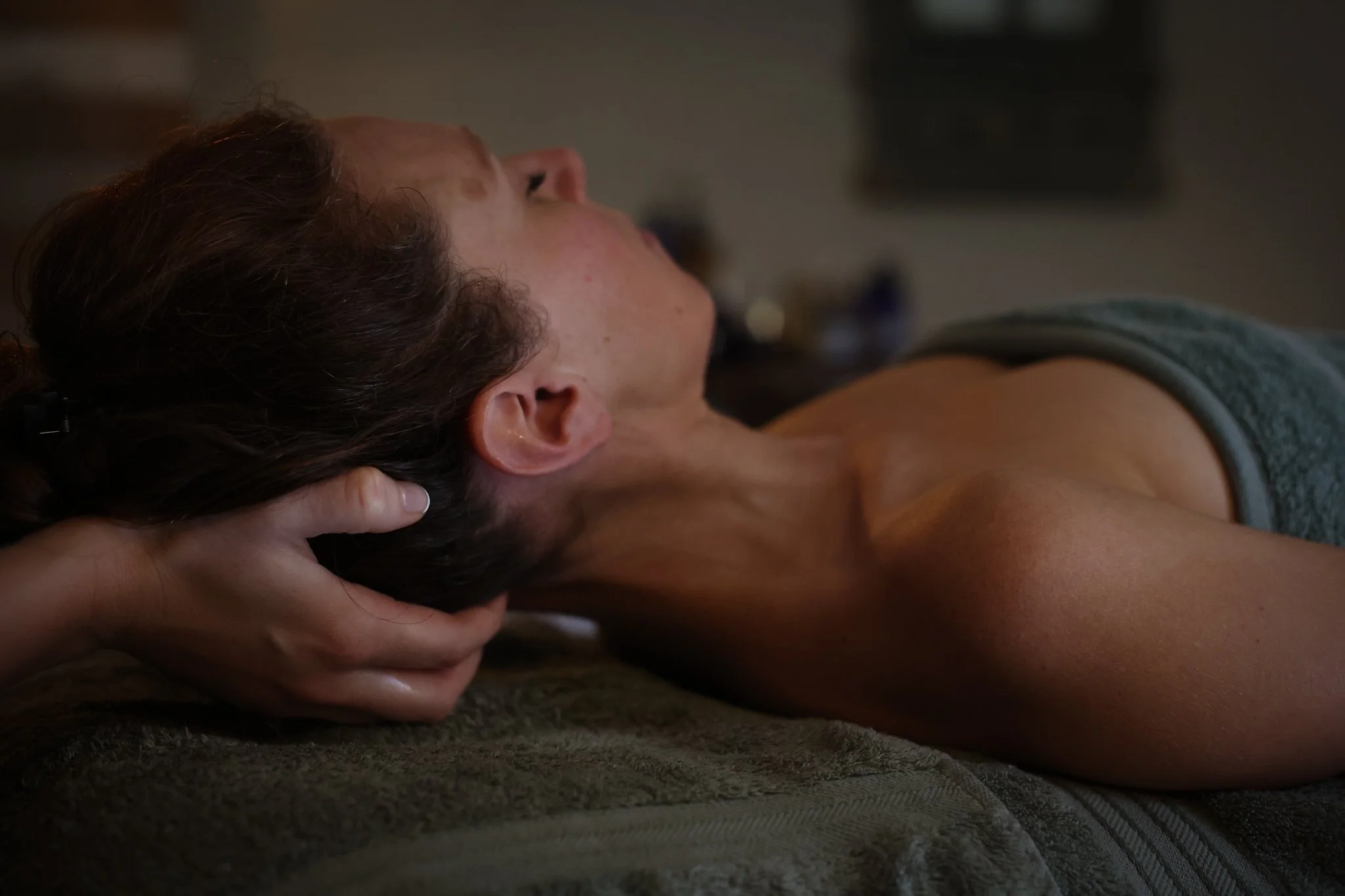 Person receiving a massage focussed on the neck area to relieve tension and headaches.
