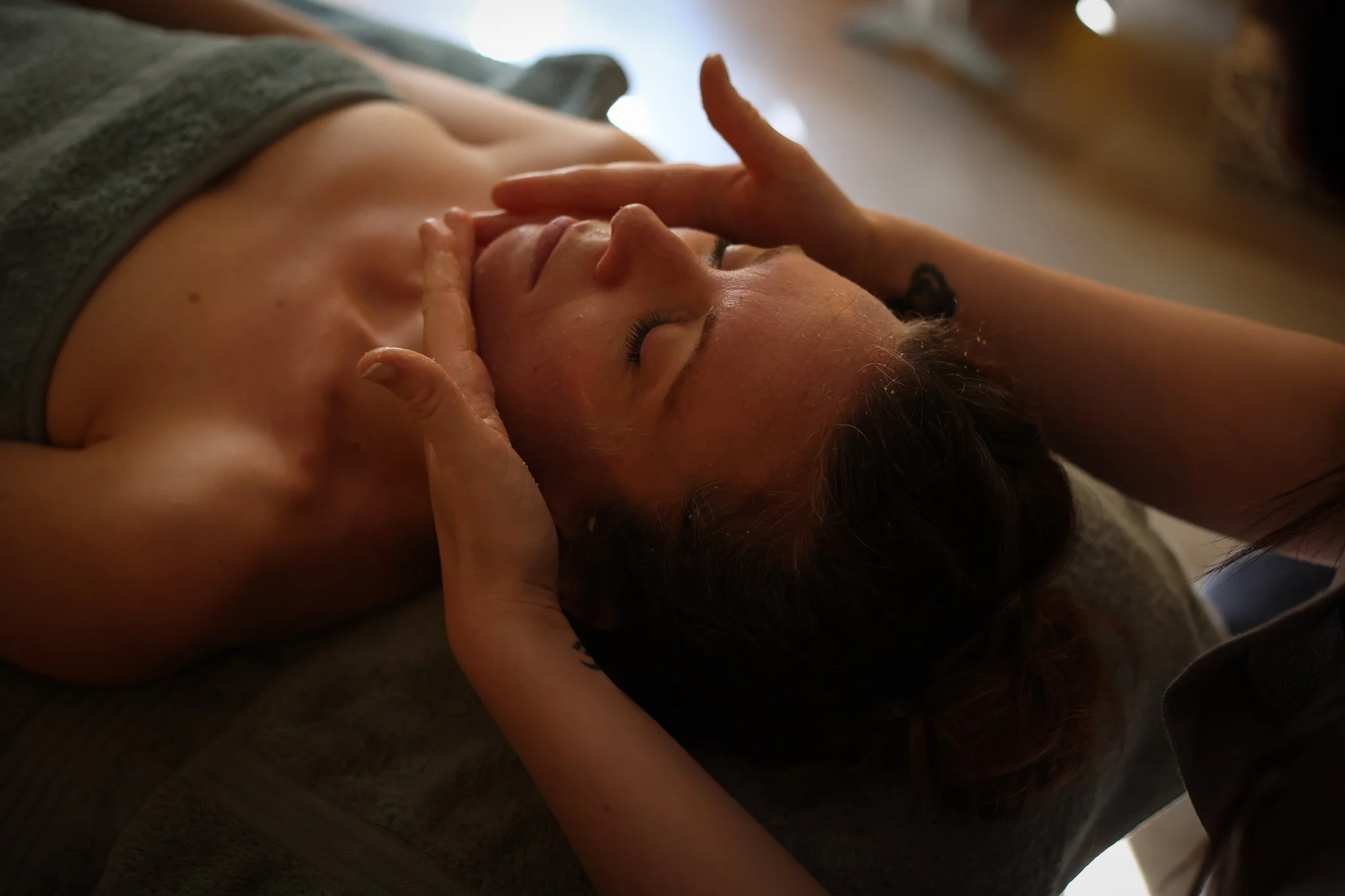 A woman having a re-hydrating Nea's Yard Remedies Facial and massage to relievev tension in her Jaw.