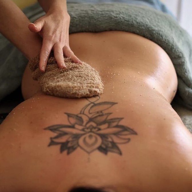 A person having a Neal's Yard Remedies Organic salt back scrub, cleanse and massage.