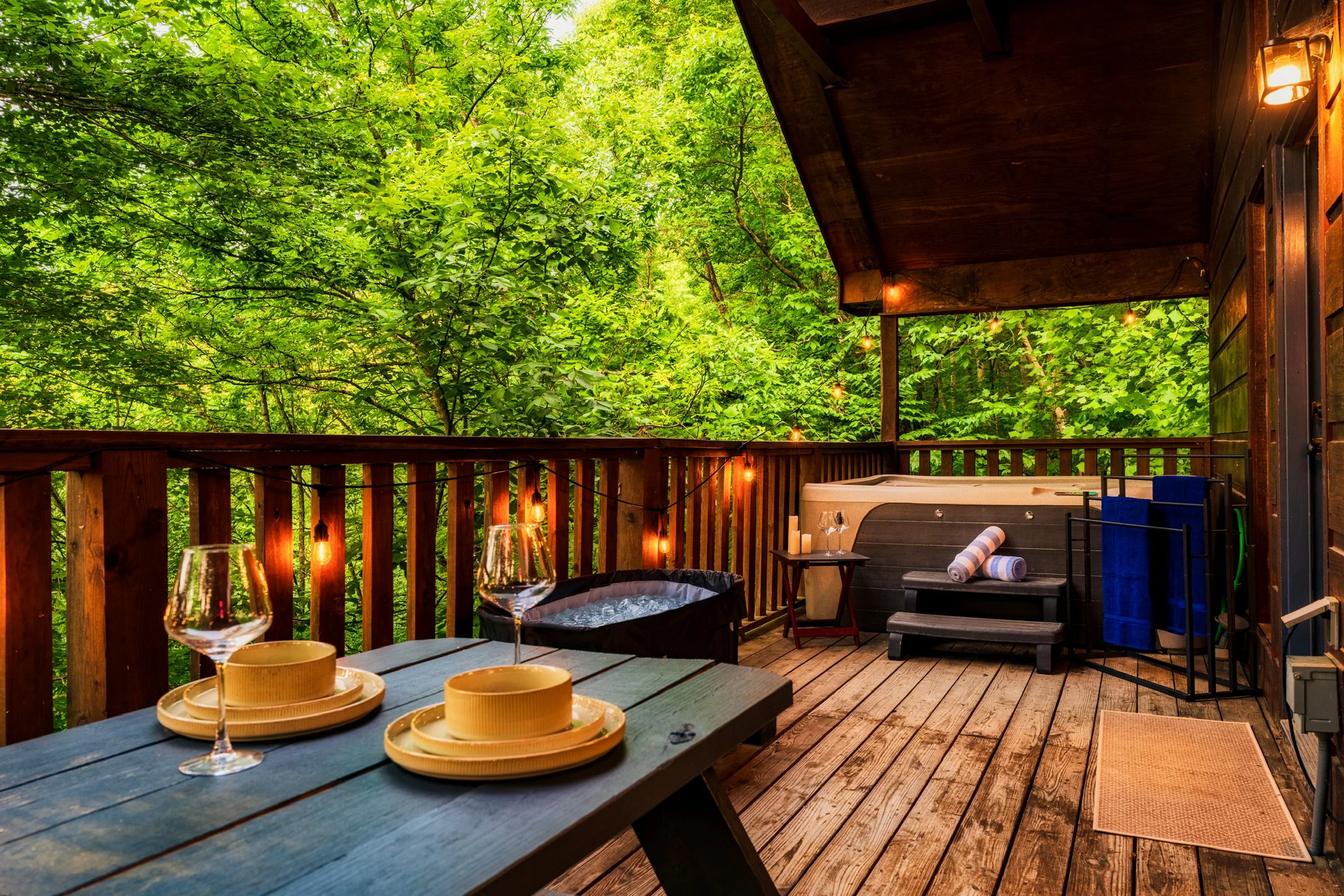 Blue Sage Hideaway upper level balcony deck dining table with wine glasses overlooking trees 