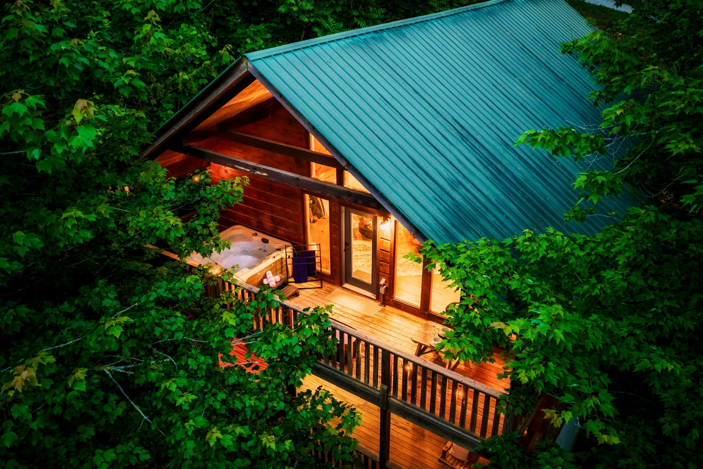Aerial view of Blue Sage Hideaway cabin in Sevierville Tennessee with teal roof and hot tub deck