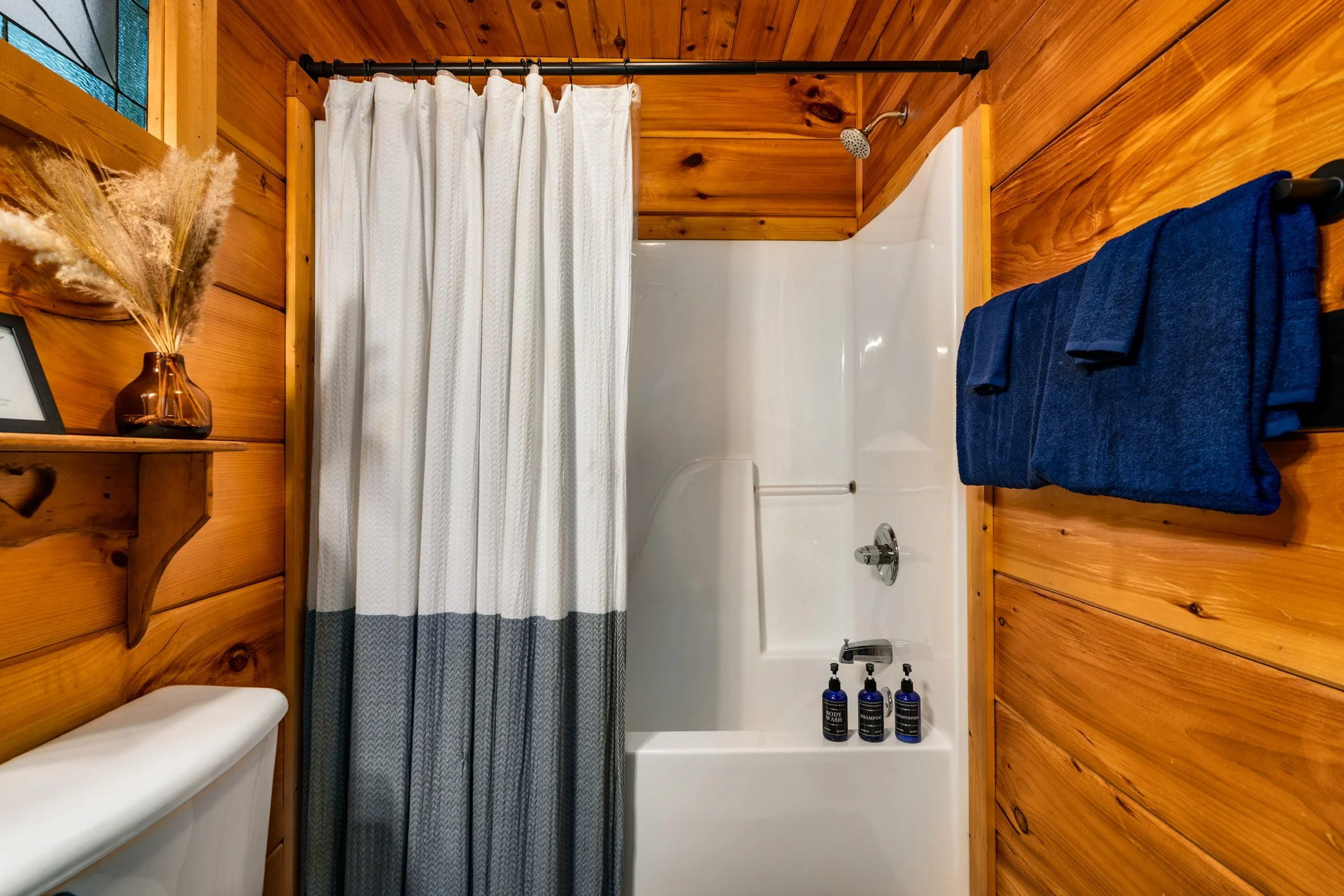Blue Sage Hideaway upper level bathroom shower and tub with striped curtain