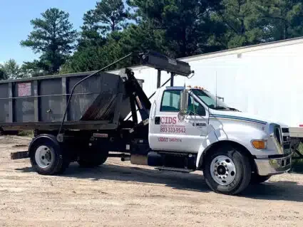 CIDS roll-off truck transporting a construction debris container