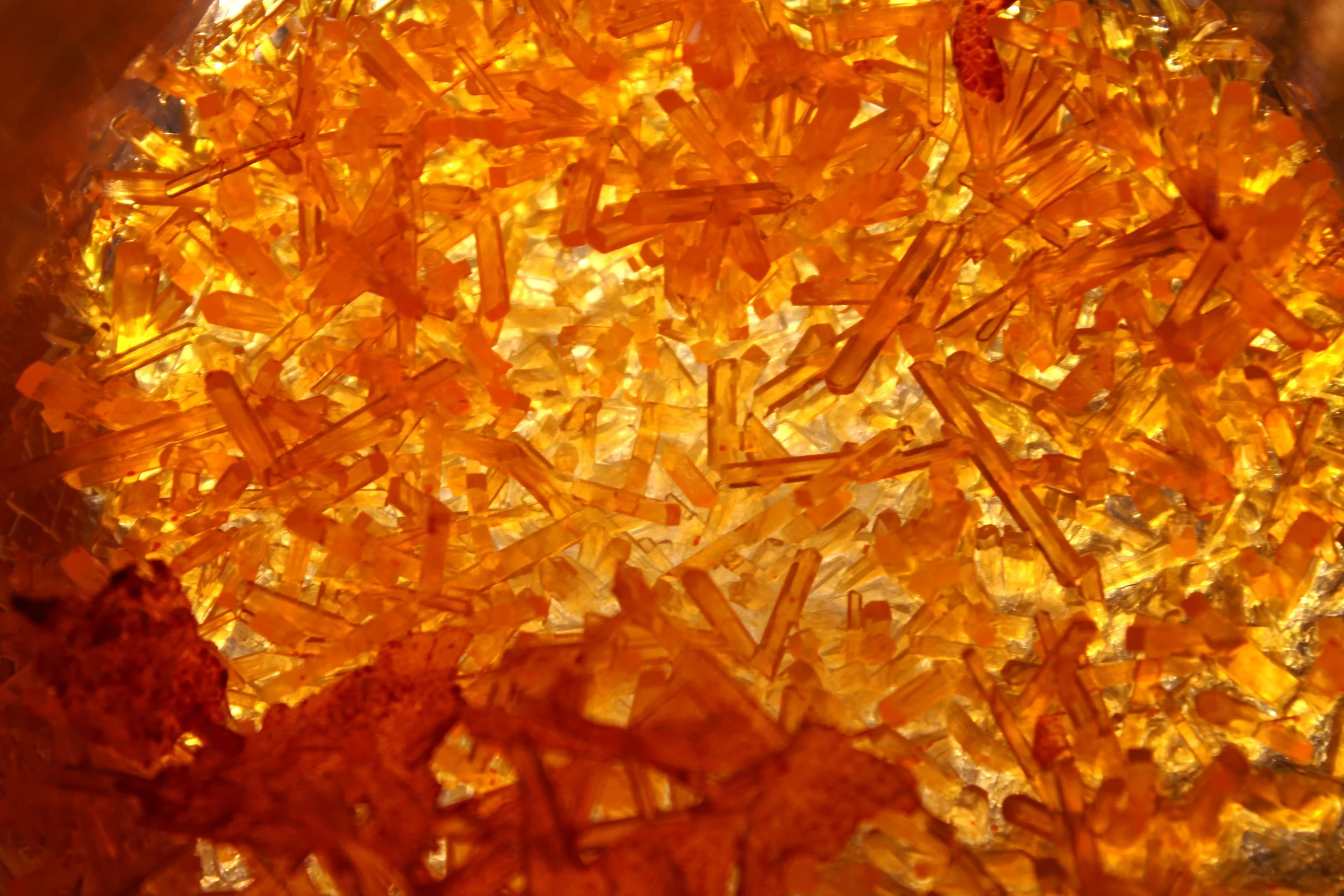 Close-up of glowing amber or orange rock salt crystals.