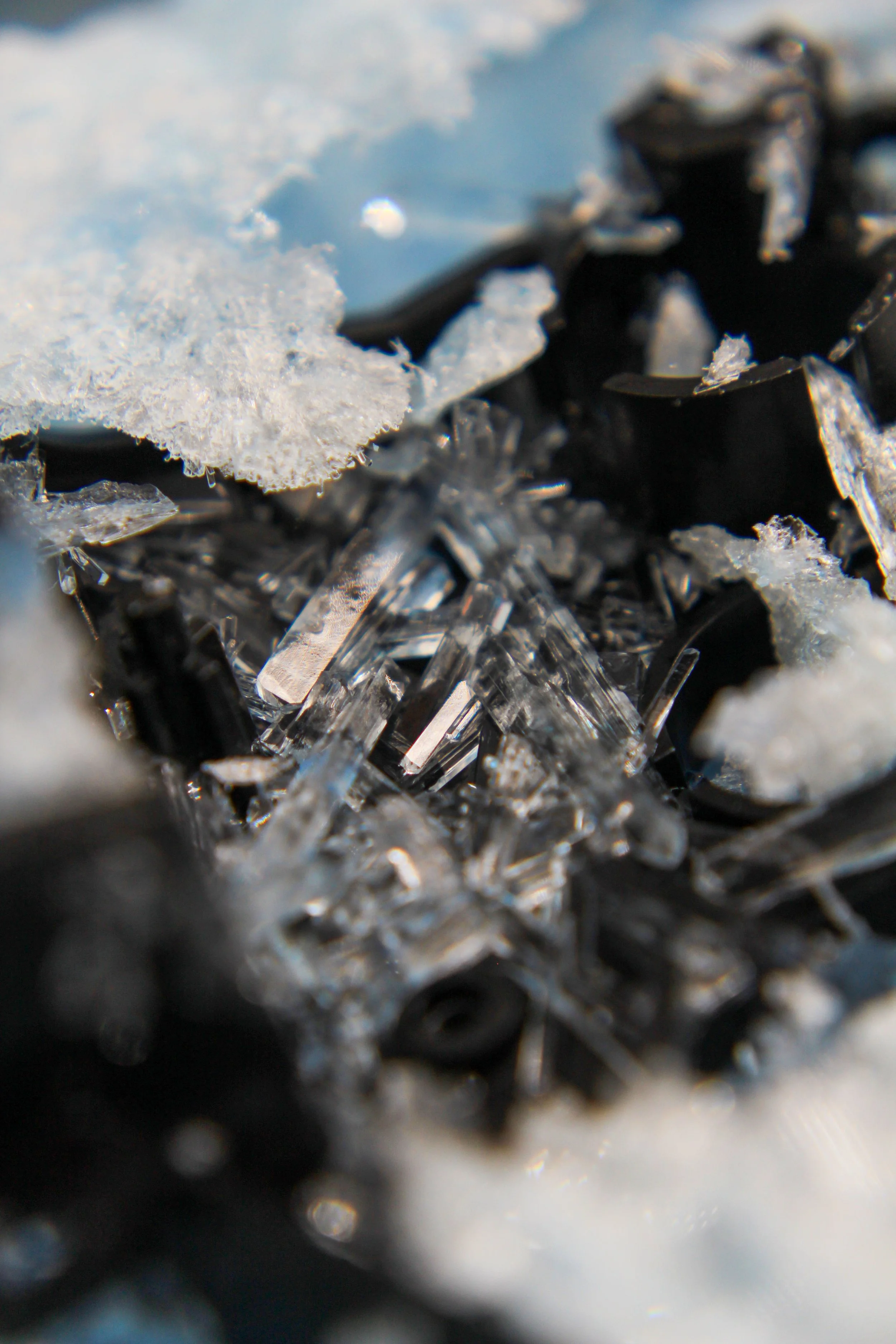 Close-up of ice crystals and metallic shavings with a snow patch in the upper left corner.