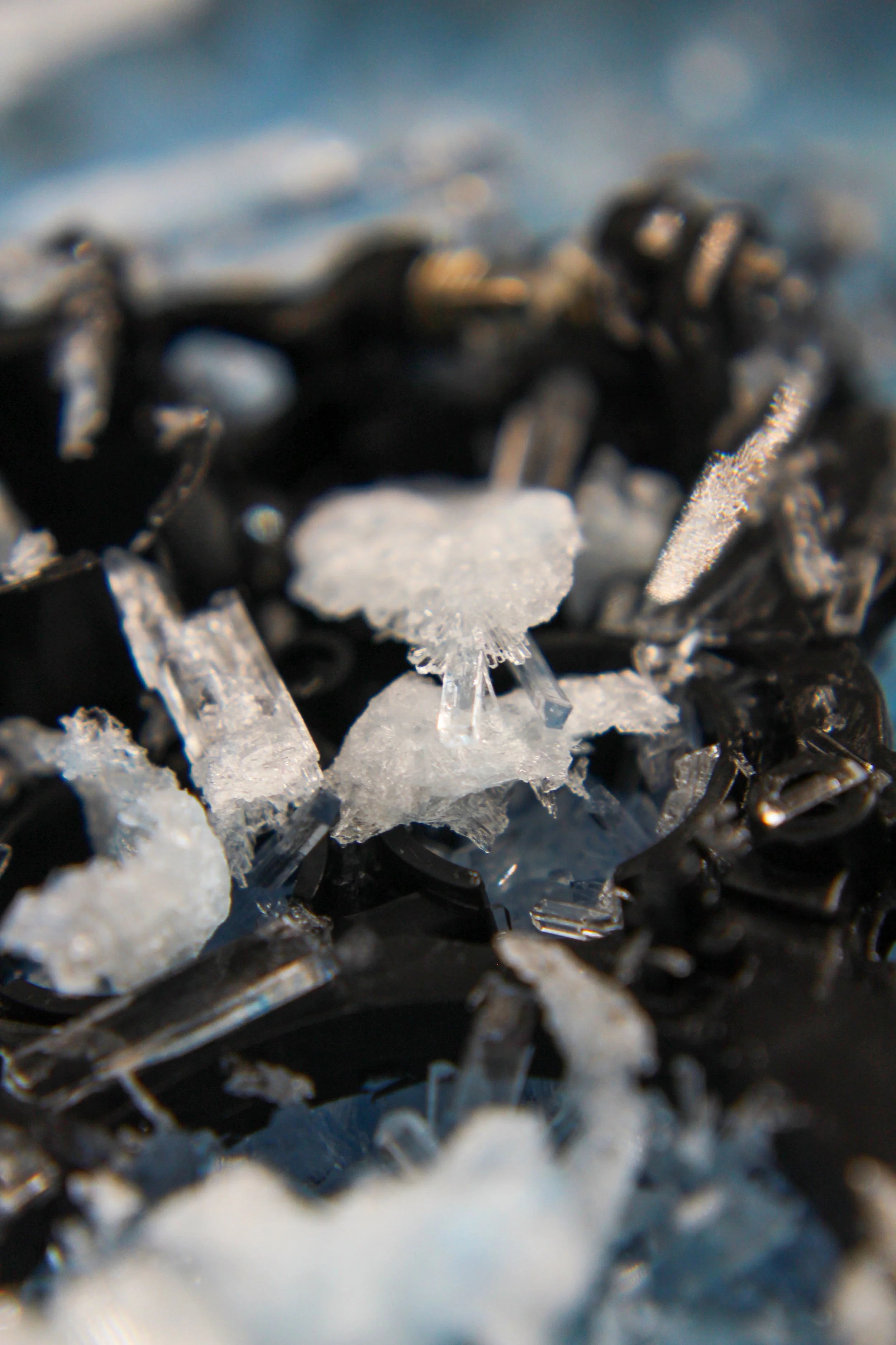 Close-up of black and white salt crystals and black sparkly beads or stones.