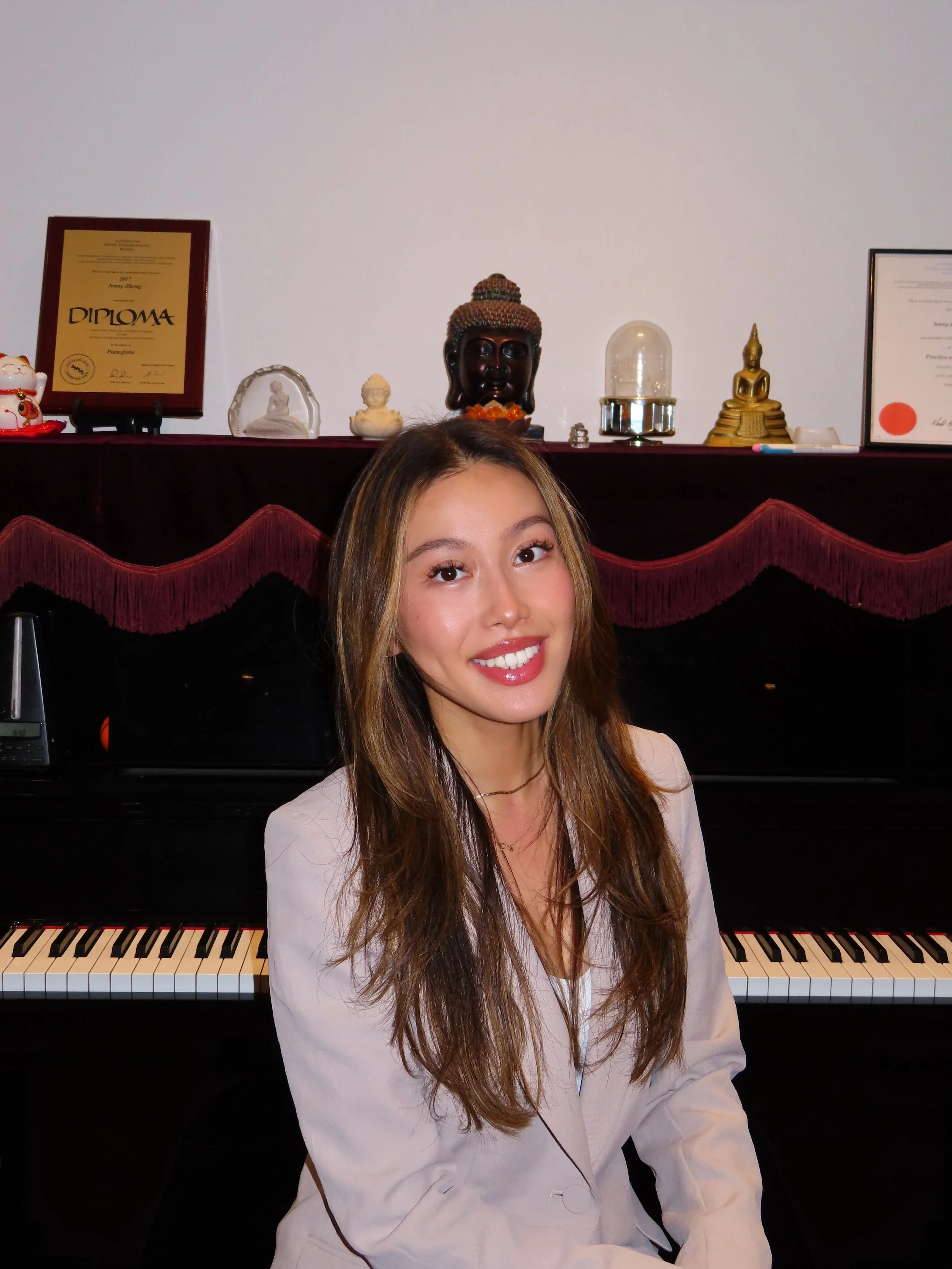 Music director sitting in front of the piano, where she teaches in her studio.
