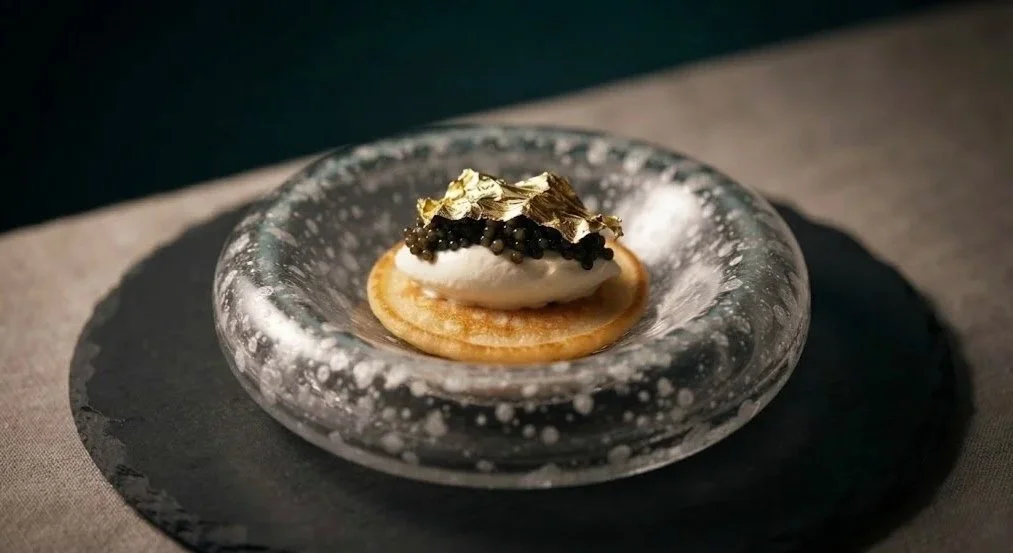 Curated luxury caviar and champagne pairing flight highlighting bespoke farm-to-bump sensory hospitality.