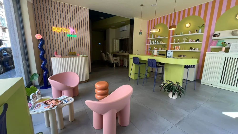 L’interno di agroomi skin lab a Torino, con poltrone rosa e arredi colorati