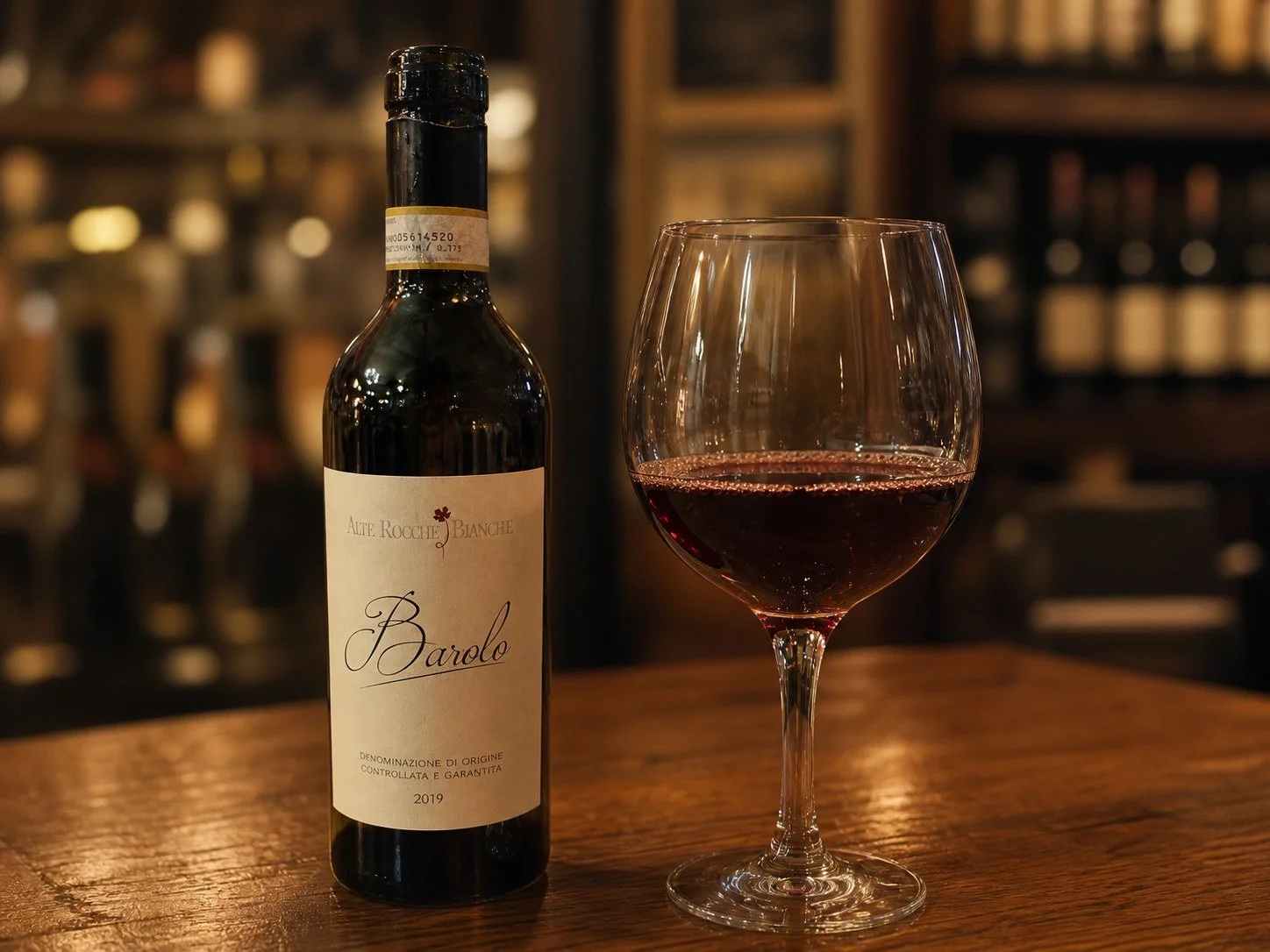 A glass of Barolo beside the wine bottle