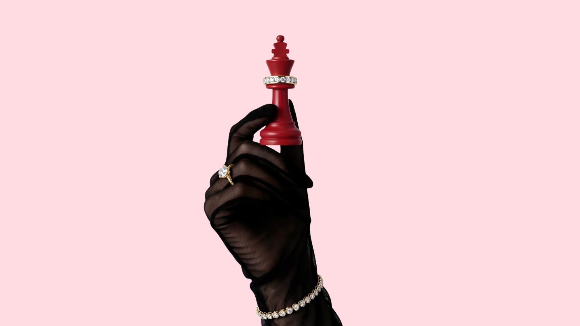 A hand in a black glove holding a red chess king piece, decorated with jewelry, against a pink background.