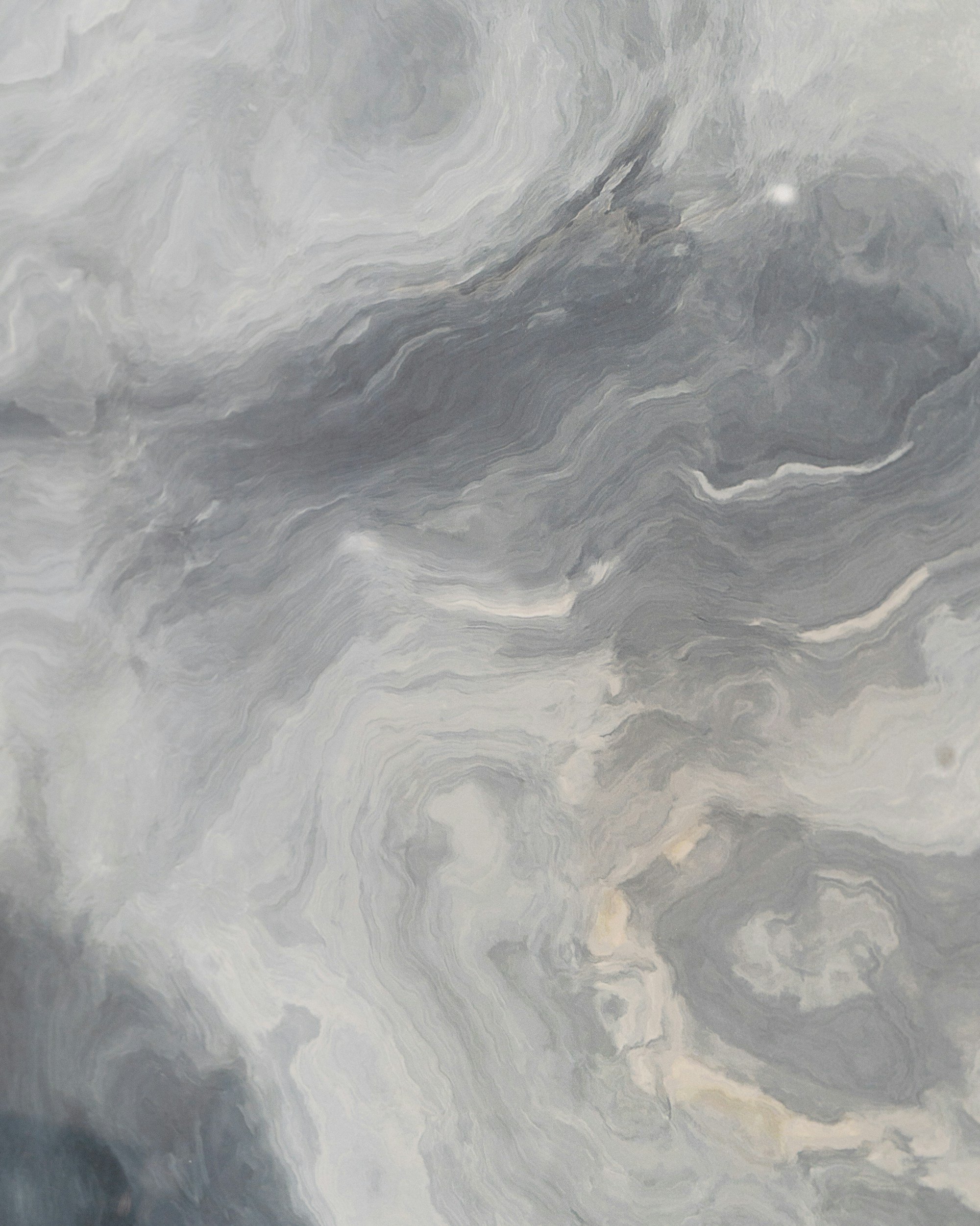 Close-up view of a marble surface with swirling gray, white, and black patterns.