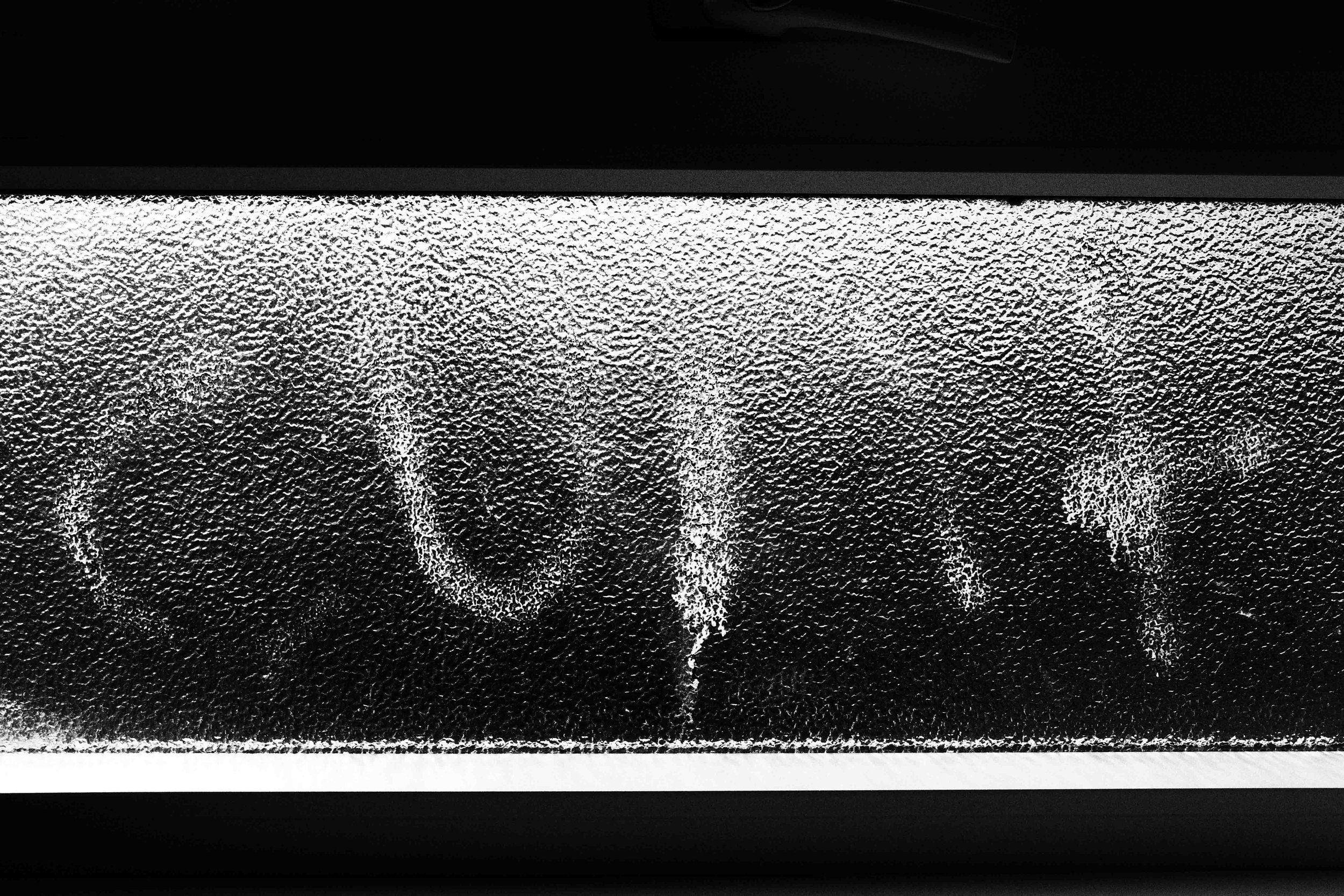 Close-up of a black surface with a textured, metallic-looking panel and a thin, straight line at the top edge.