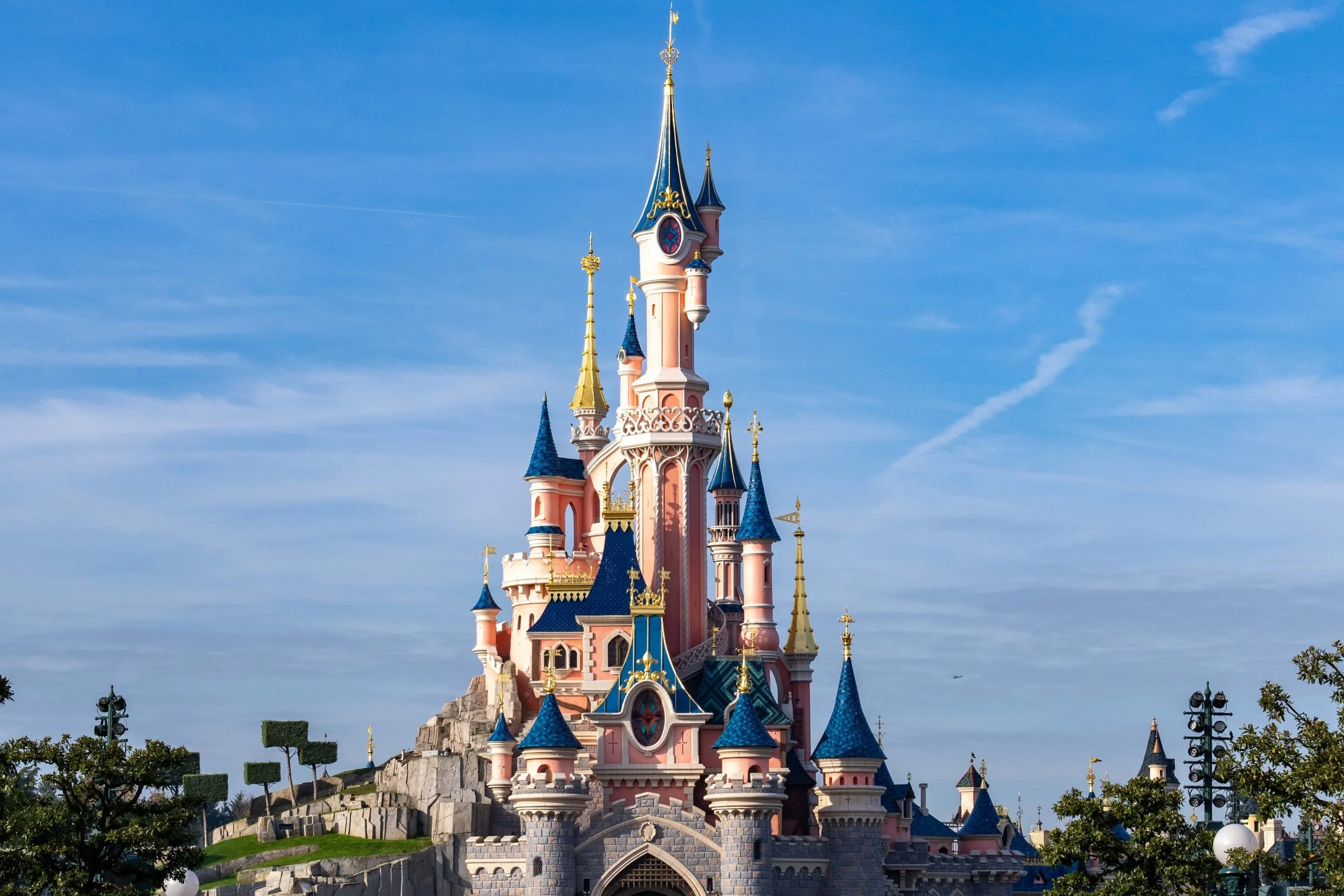 Sleeping Beauty Castle at Disneyland Paris rising above the gardens and guests in Central Plaza