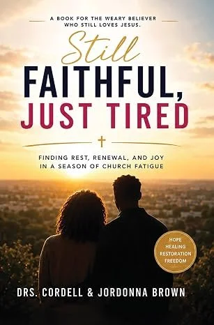 The cover of a faith-based book titled "Still Faithful, Just Tired" by Drs. Cordell and Jordonna Brown, featuring a silhouette of a couple looking at a sunset over a cityscape, with words indicating themes of hope, healing, restoration, and freedom.