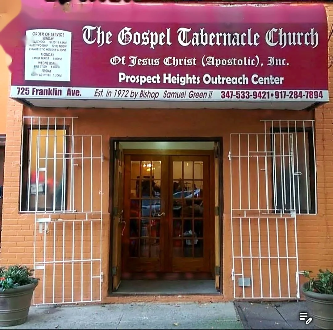 Sign for The Gospel Tabernacle Church of Jesus Christ (Apostolic) Inc., Prospect Heights Outreach Center, located at 725 Franklin Ave, with service hours and contact information, in front of a brick building with double wooden doors and metal security gates on the windows.